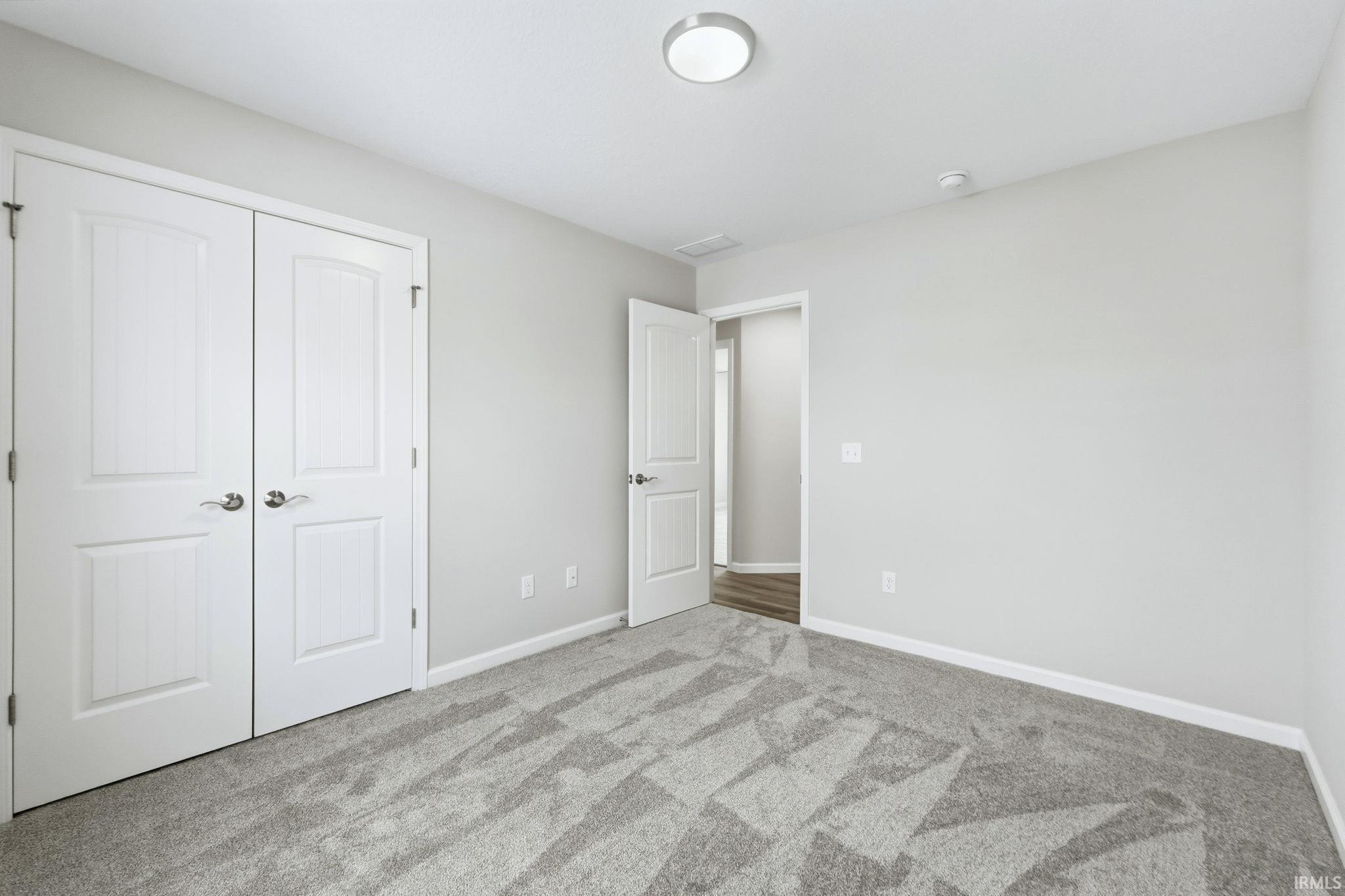 Unfurnished bedroom with carpet and a closet