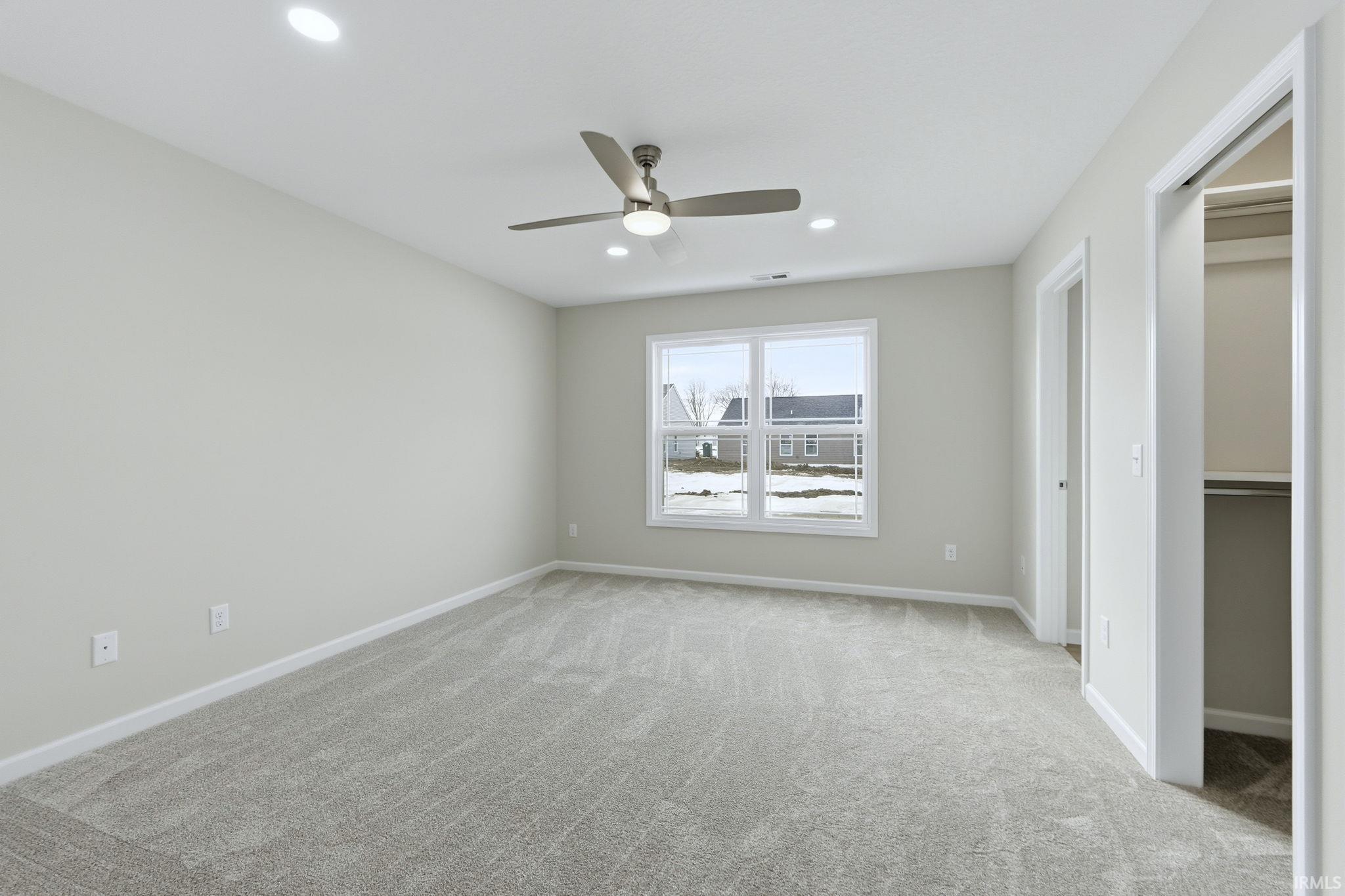 Unfurnished bedroom featuring light colored carpet, a ceiling fan, a closet, and recessed lighting