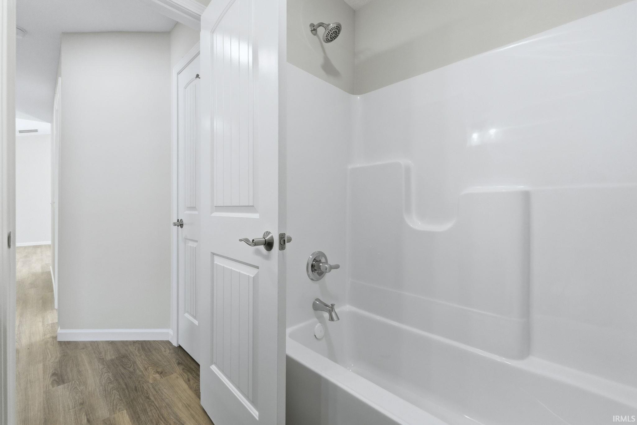 Full bath with shower / bath combination and wood finished floors