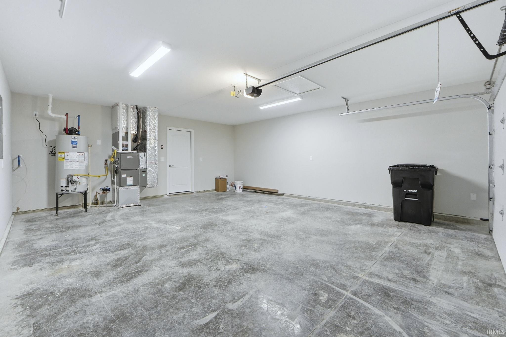 Garage featuring heating unit and gas water heater