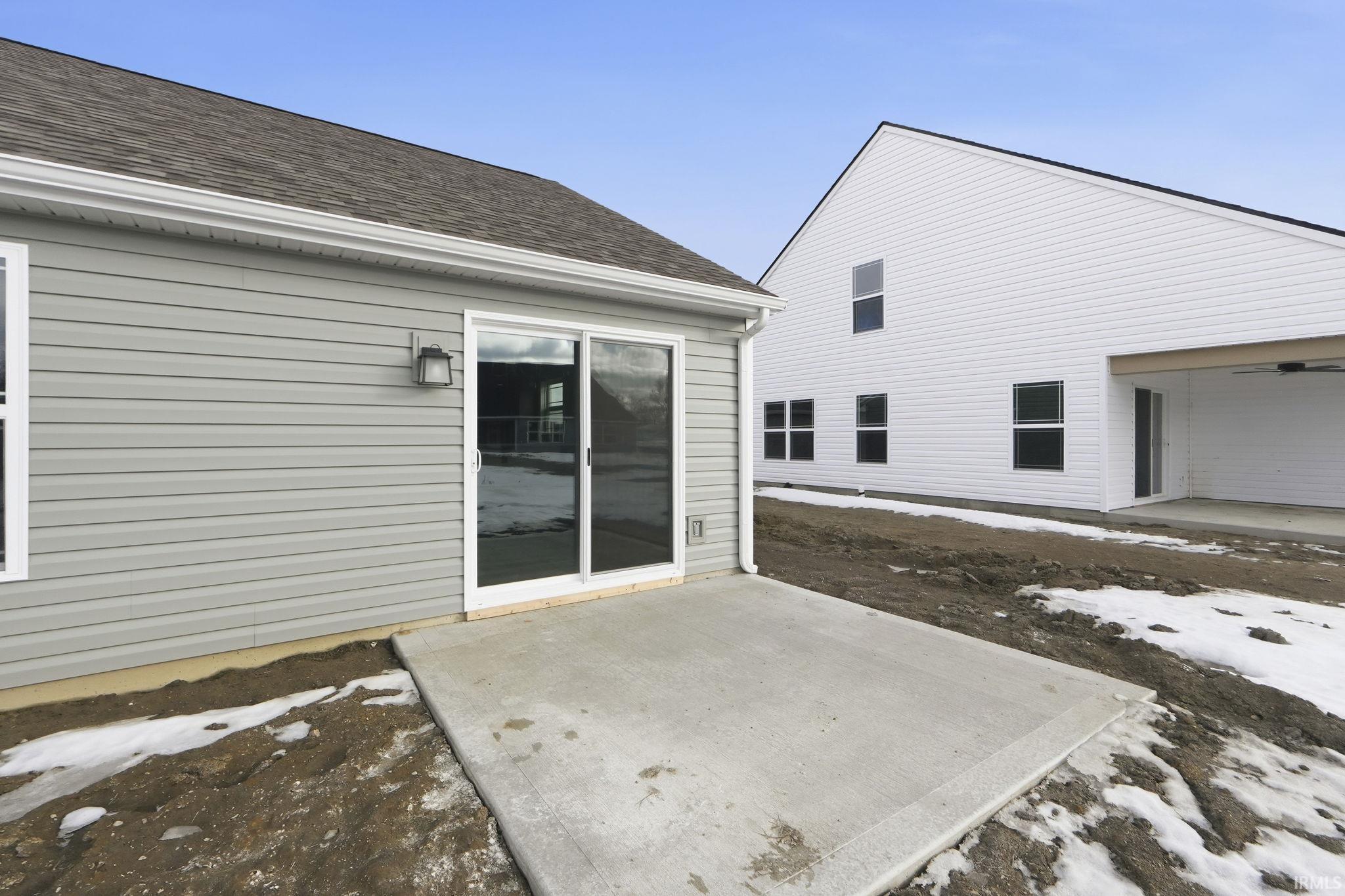 Rear view of property with a patio area and a shingled roof