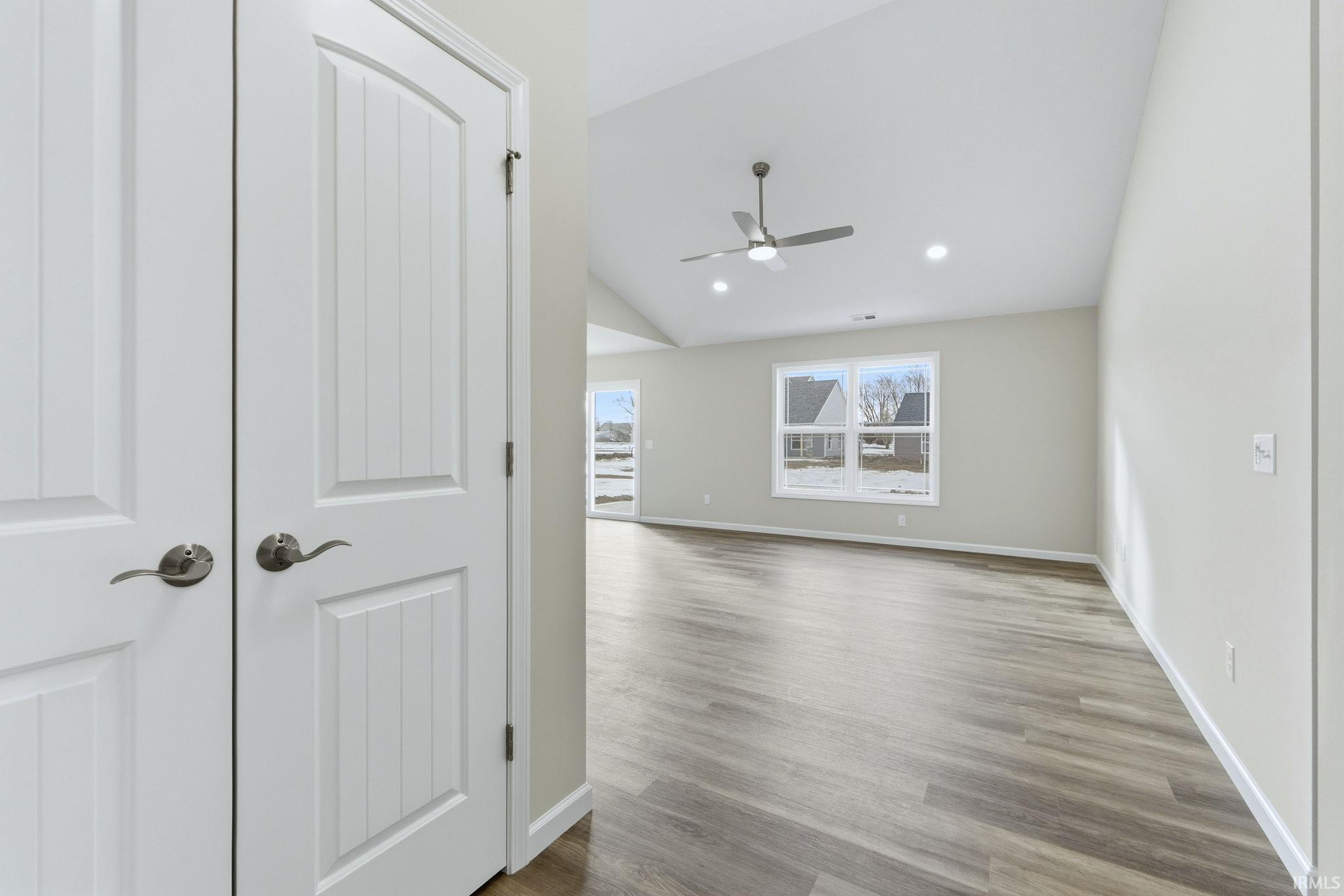 Spare room with a ceiling fan, wood finished floors, lofted ceiling, and recessed lighting