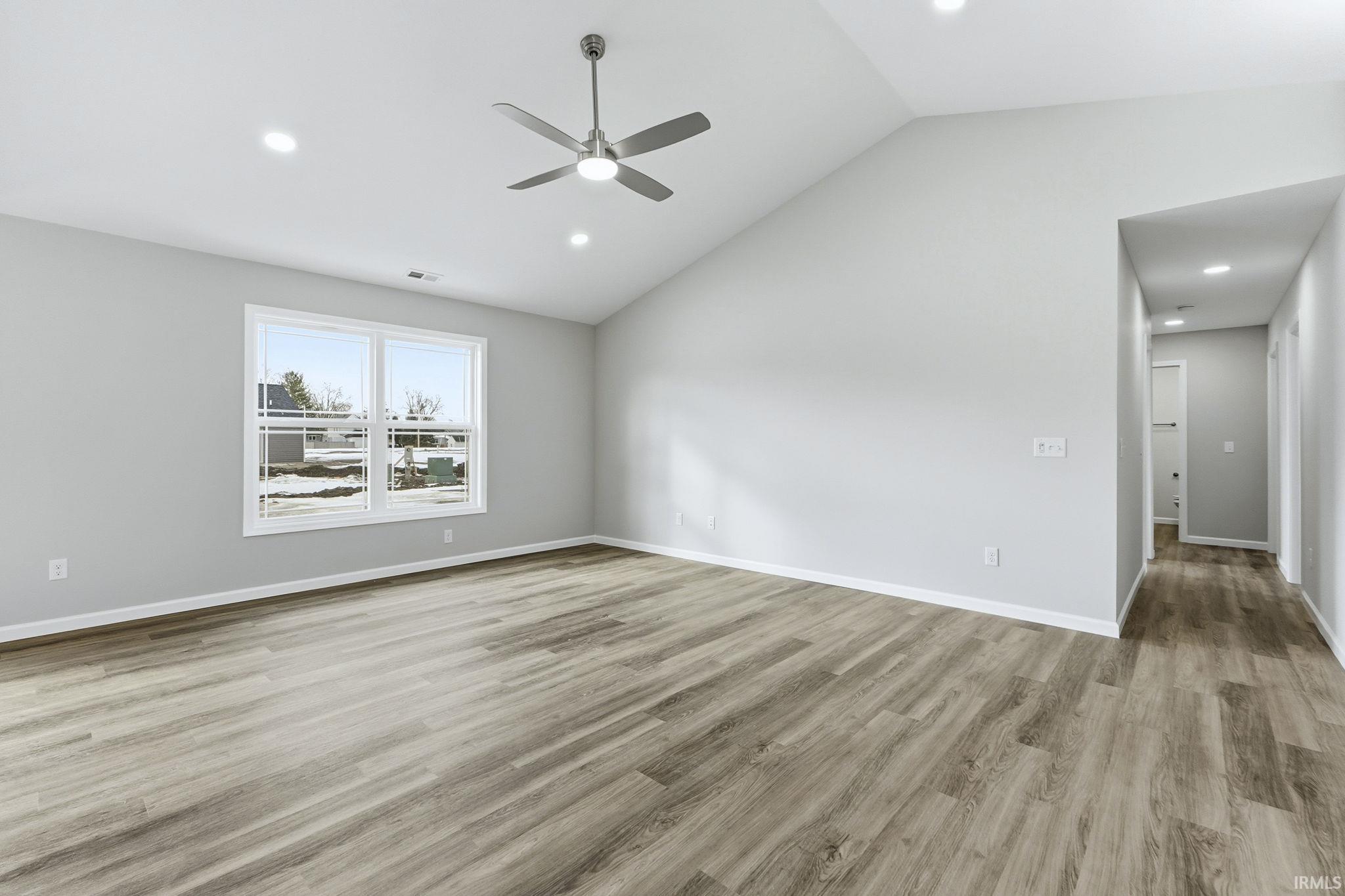 Empty room with lofted ceiling, a ceiling fan, light wood-style flooring, and recessed lighting