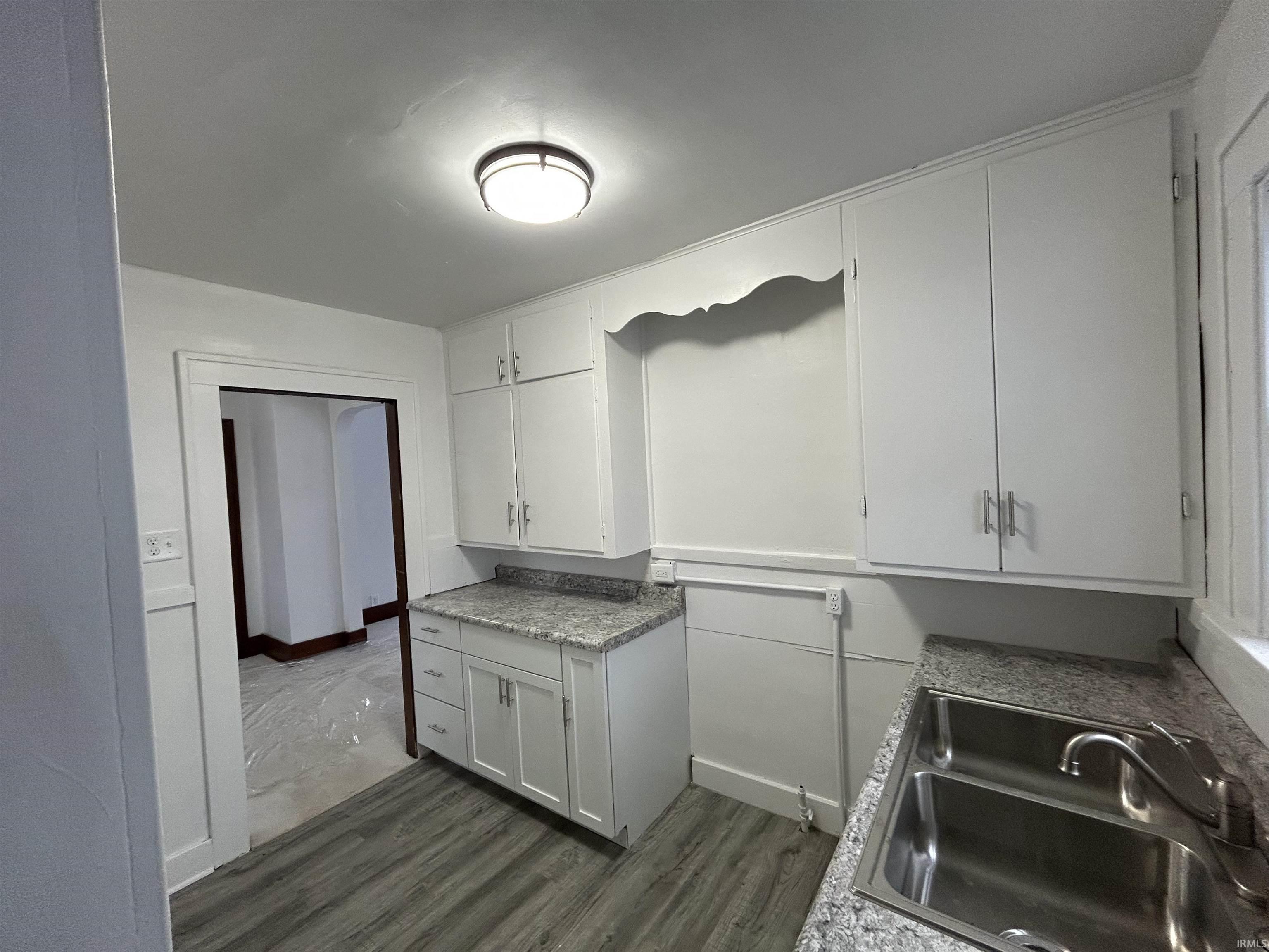 Kitchen featuring white cabinetry and dark wood finished floors
