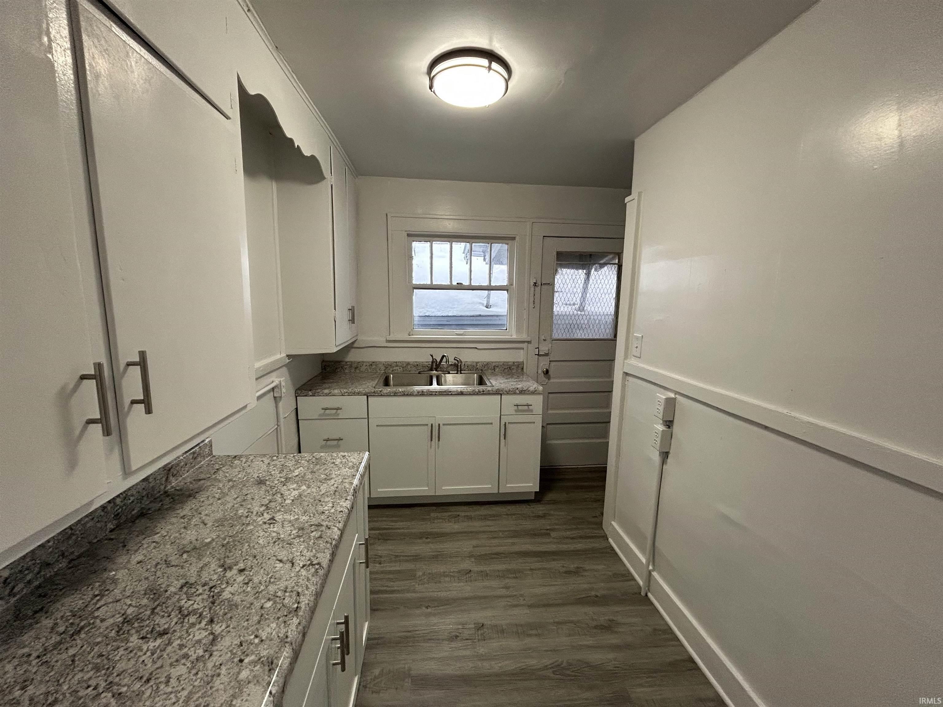 Kitchen with white cabinets and dark wood-style flooring