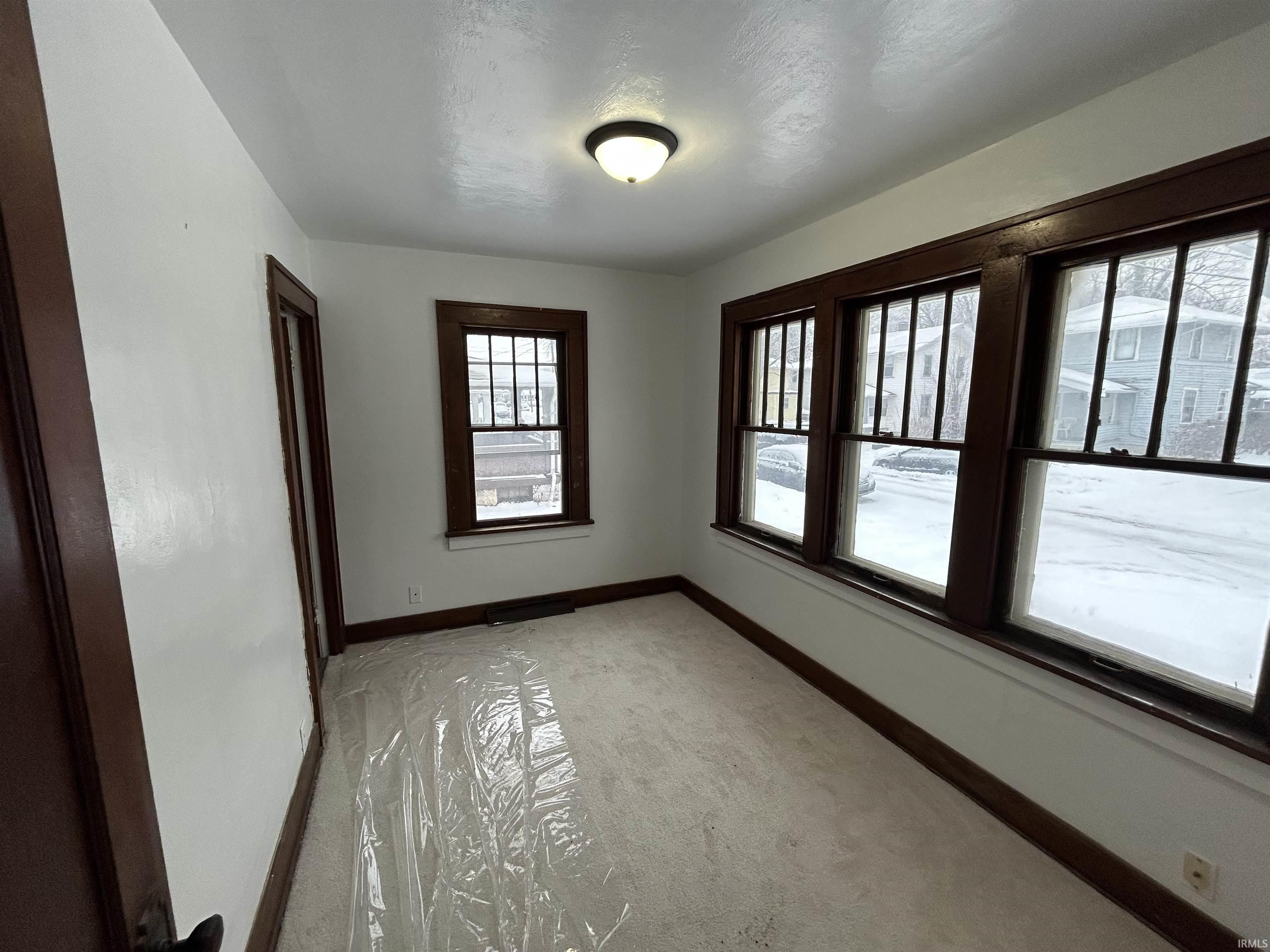 Spare room featuring baseboards and light carpet