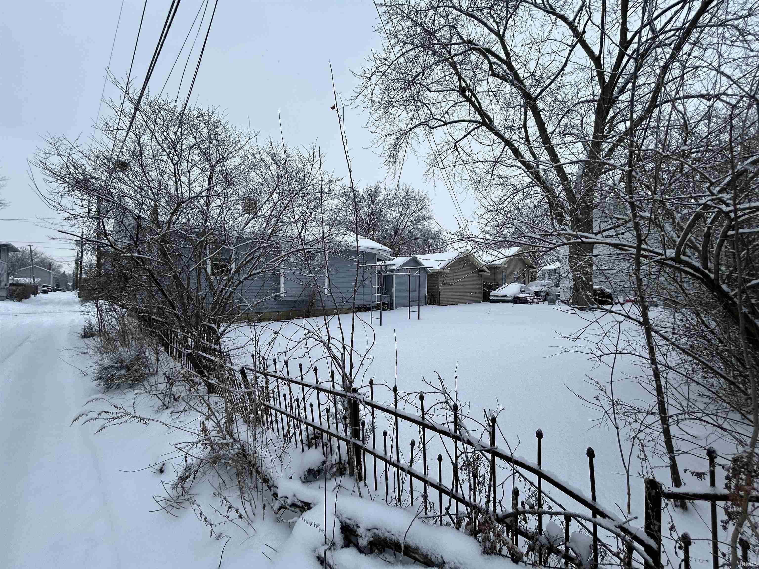 Yard covered in snow featuring a residential view