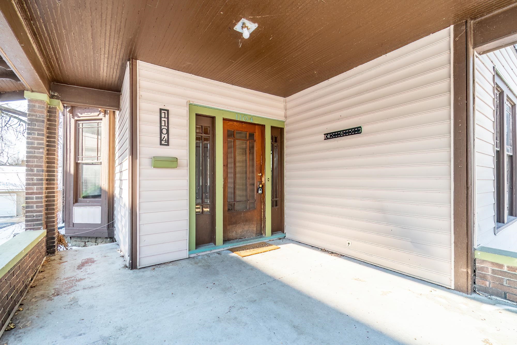 Doorway to property featuring covered porch