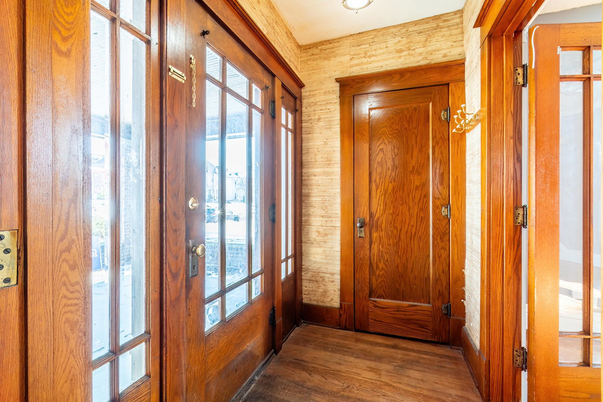 Doorway with wood finished floors and wood walls