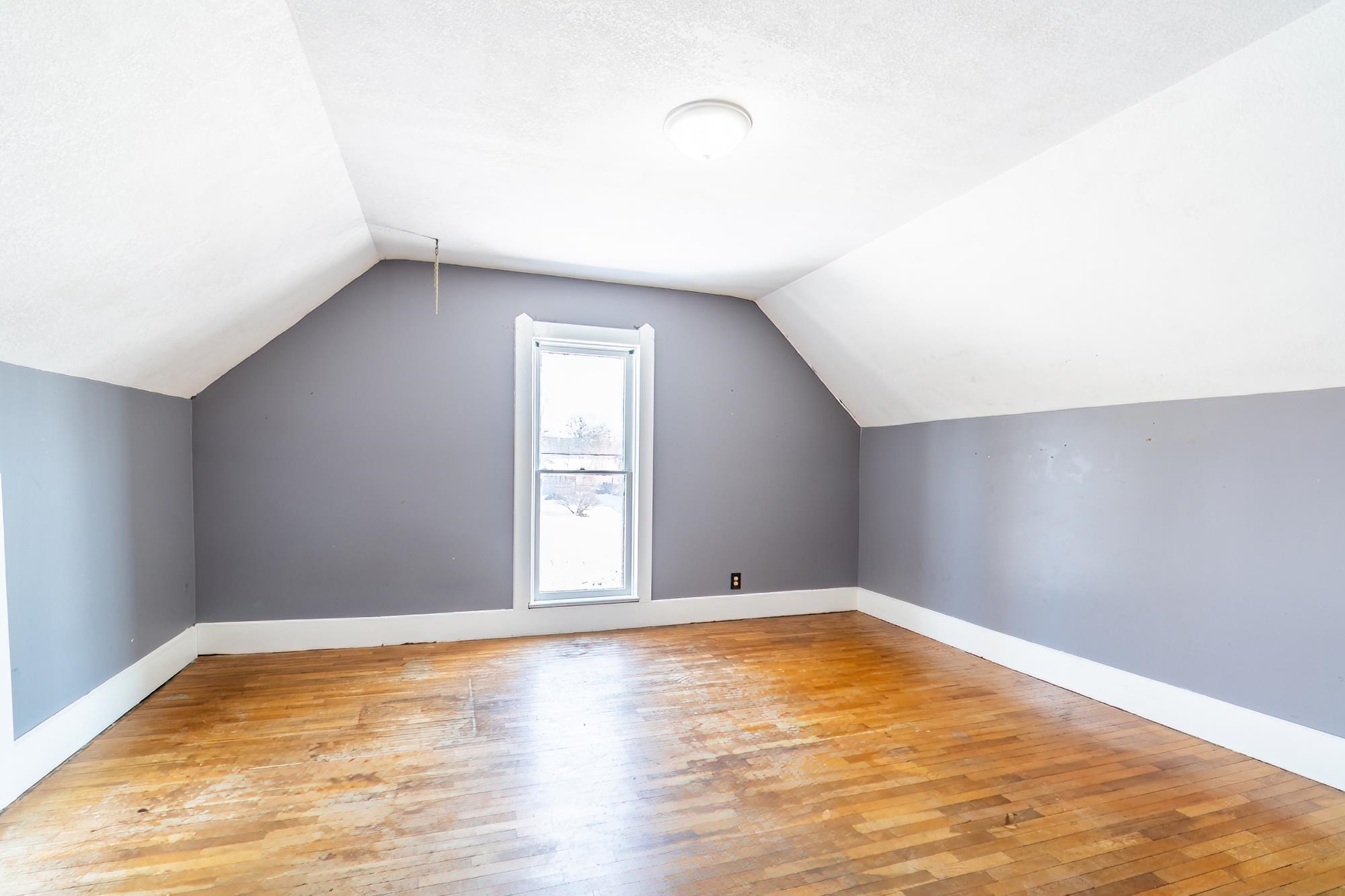 Bedroom with hardwood floors, and lofted ceiling
