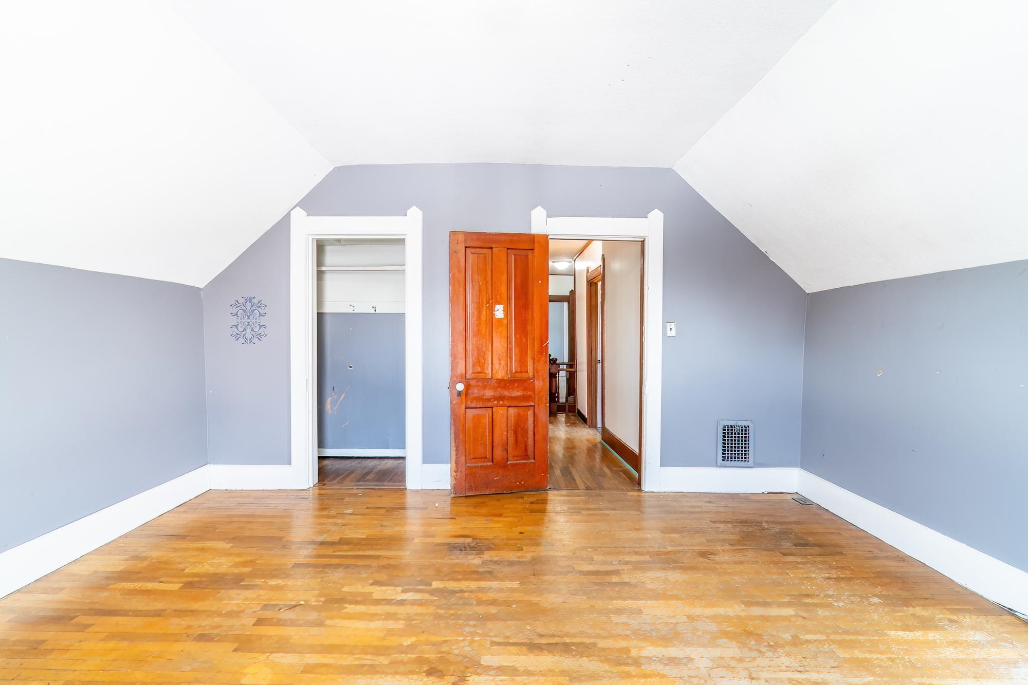 Bedroom with hardwood floors, and lofted ceiling