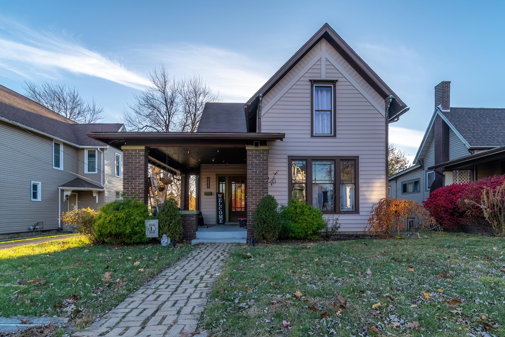 View of front of home featuring covered porch and a front yard
