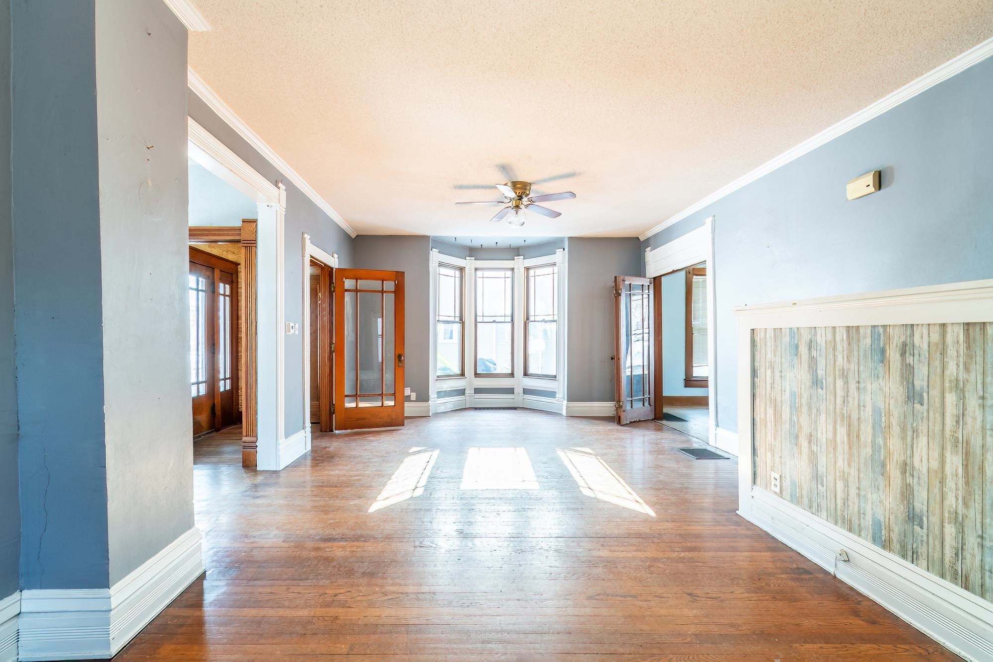 Unfurnished room featuring crown molding, french doors, hardwood flooring, ceiling fan, and a textured ceiling