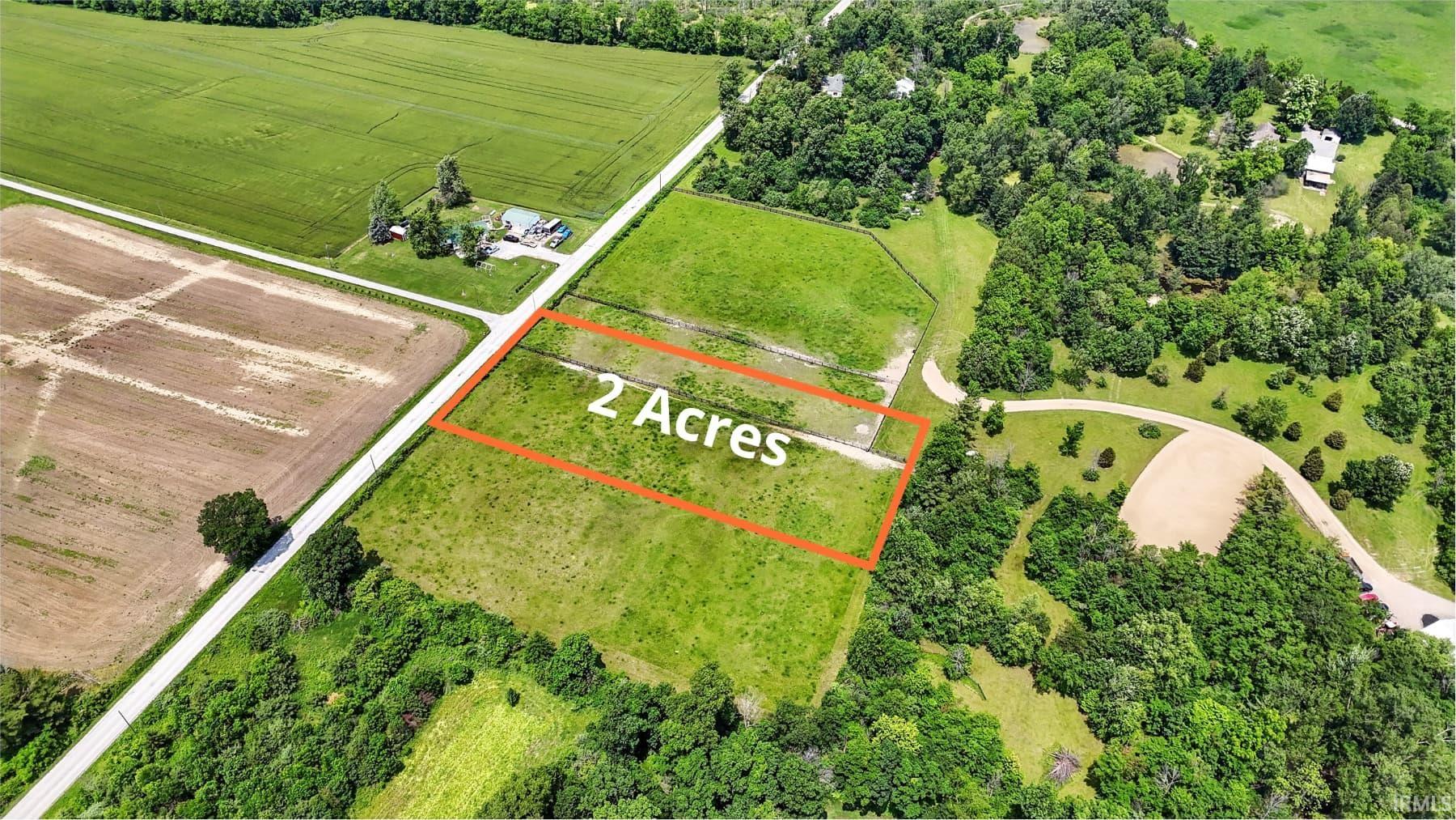 View of rural area with property parcel outlined and large plots for crops