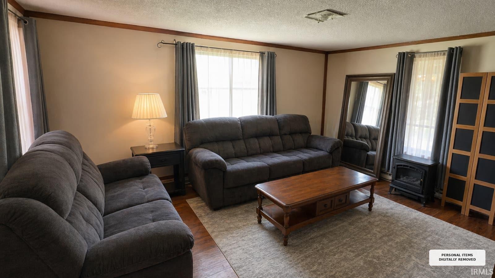 Living area featuring warm neutral wall tones, wood-finish flooring, and crown molding