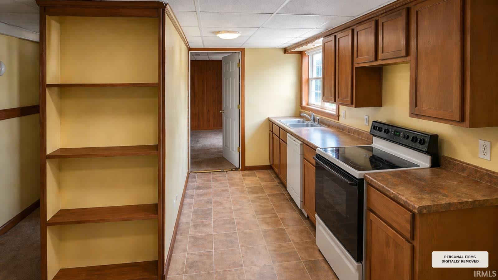 Kitchen featuring wood-finish cabinetry, a stainless steel sink, and a white electric range