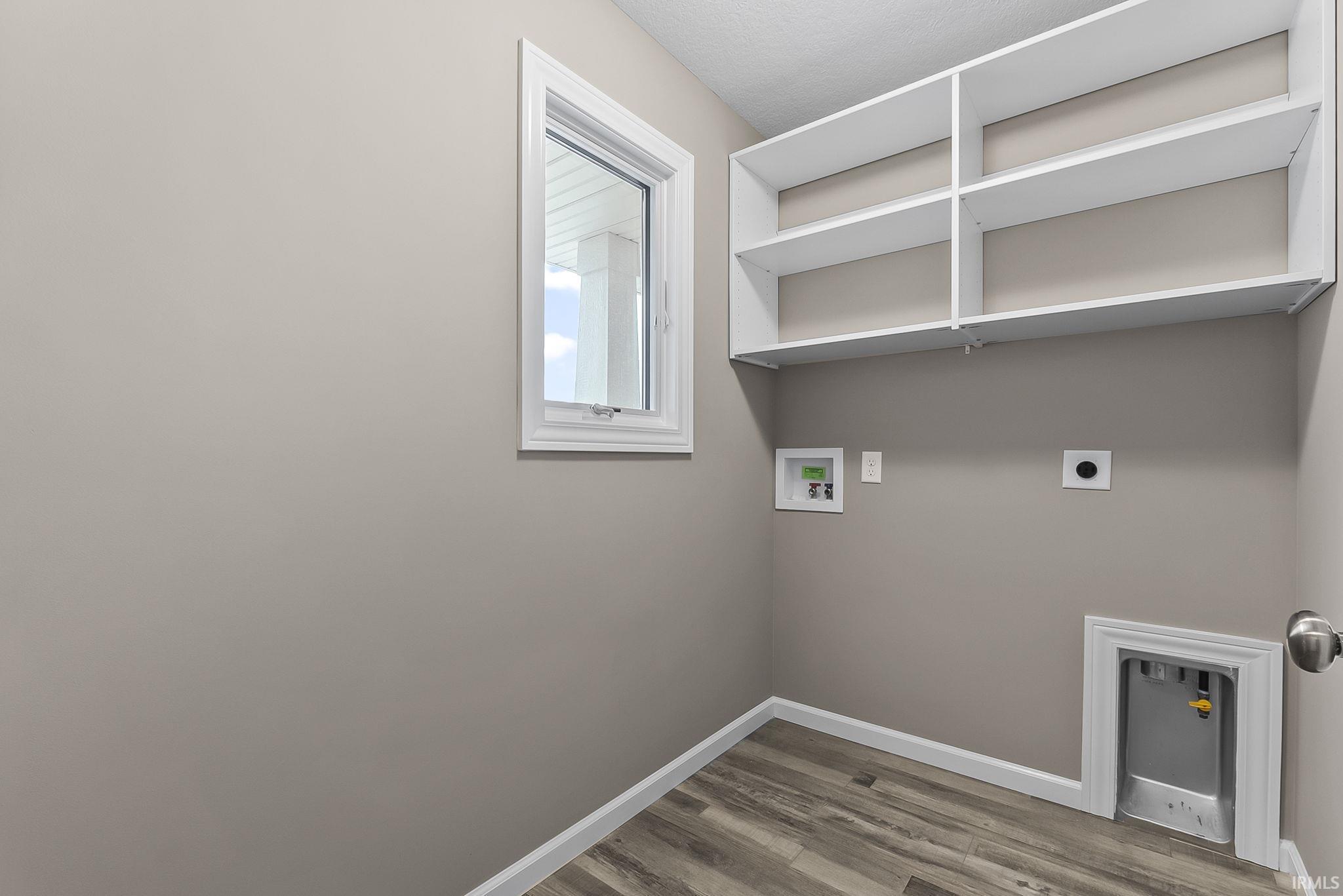 Laundry room with hookup for a washing machine, light wood-style floors, and hookup for an electric dryer