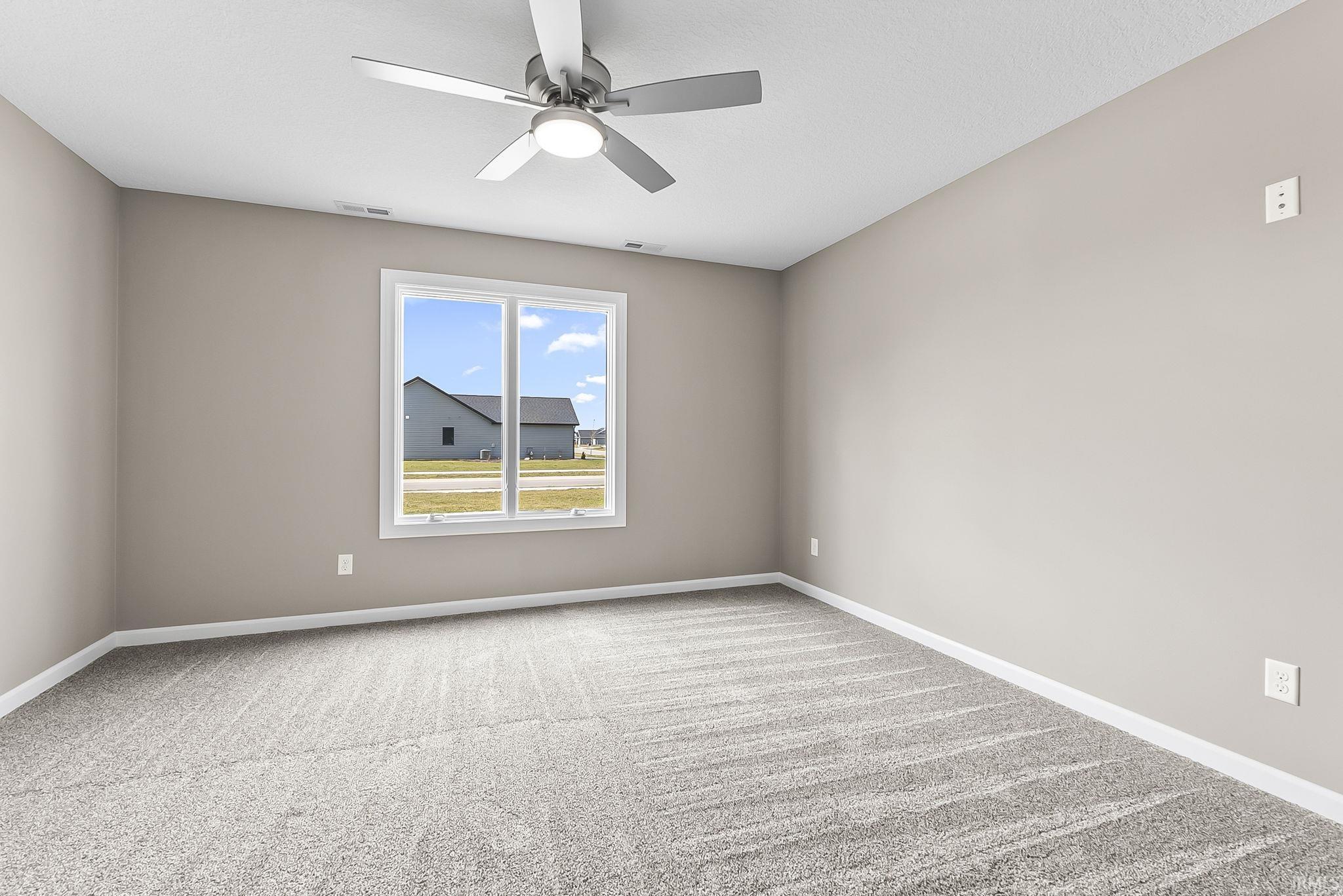 Spare room featuring light colored carpet and ceiling fan