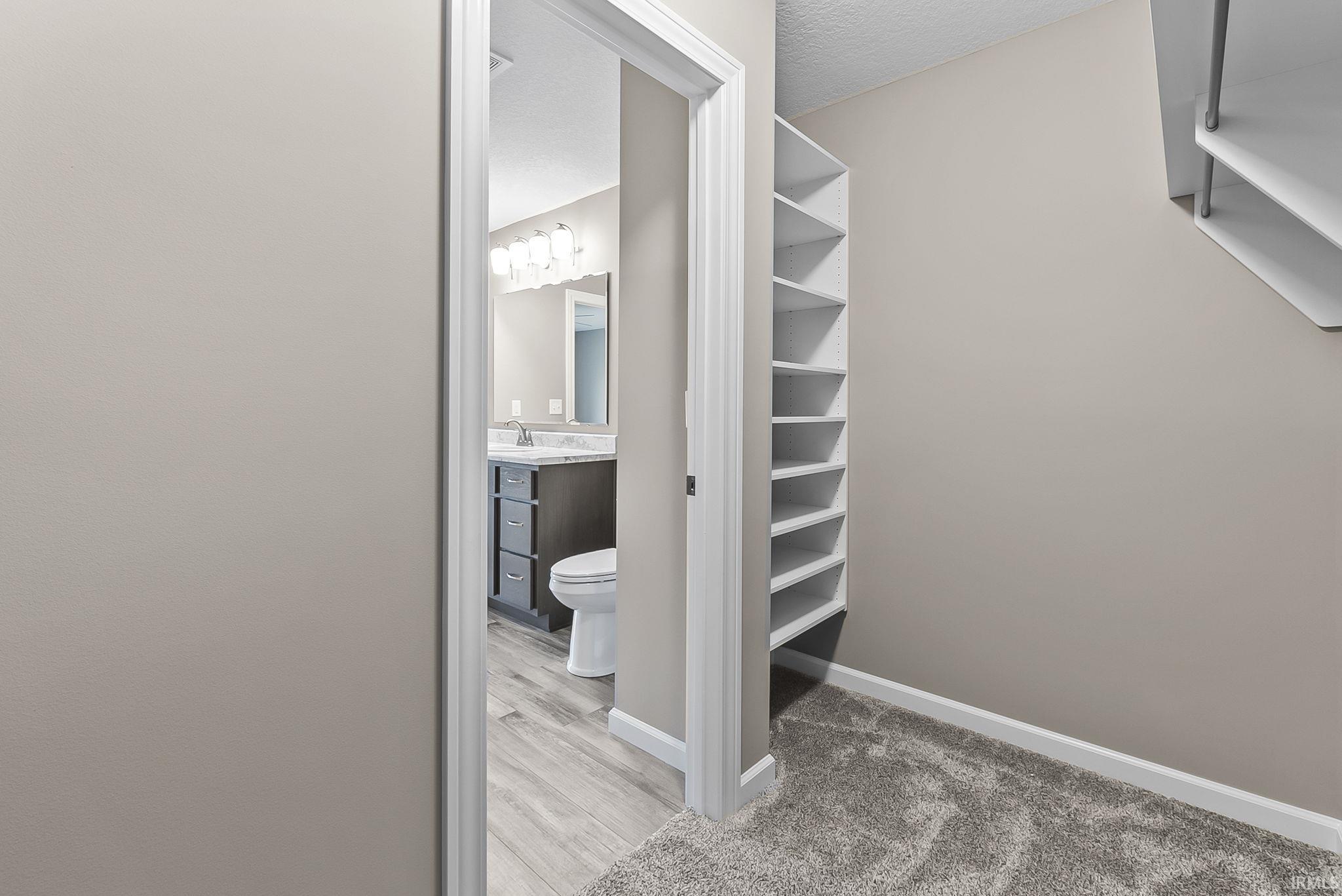 Walk in closet with light wood-style flooring