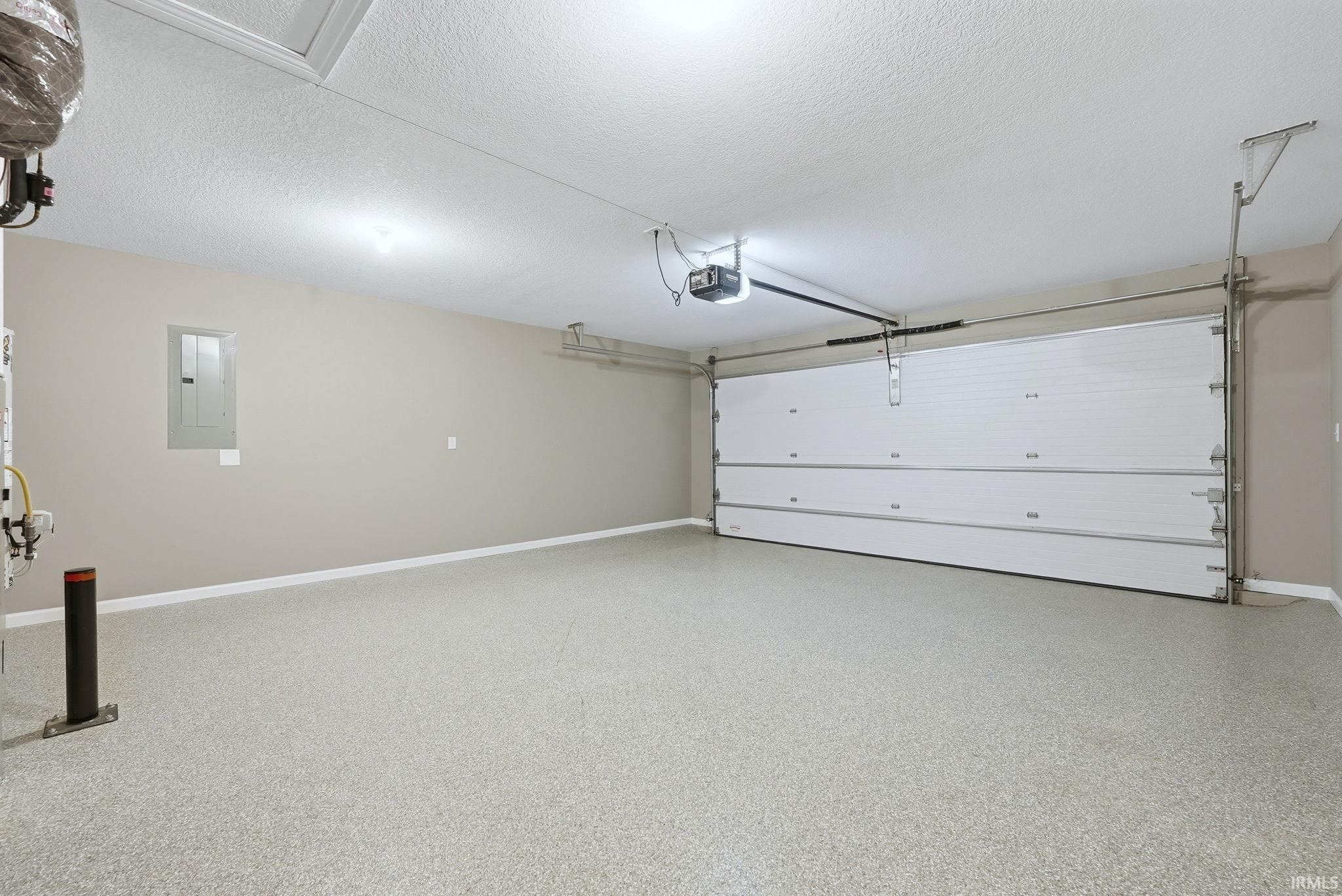 Garage featuring electric panel and a garage door opener
