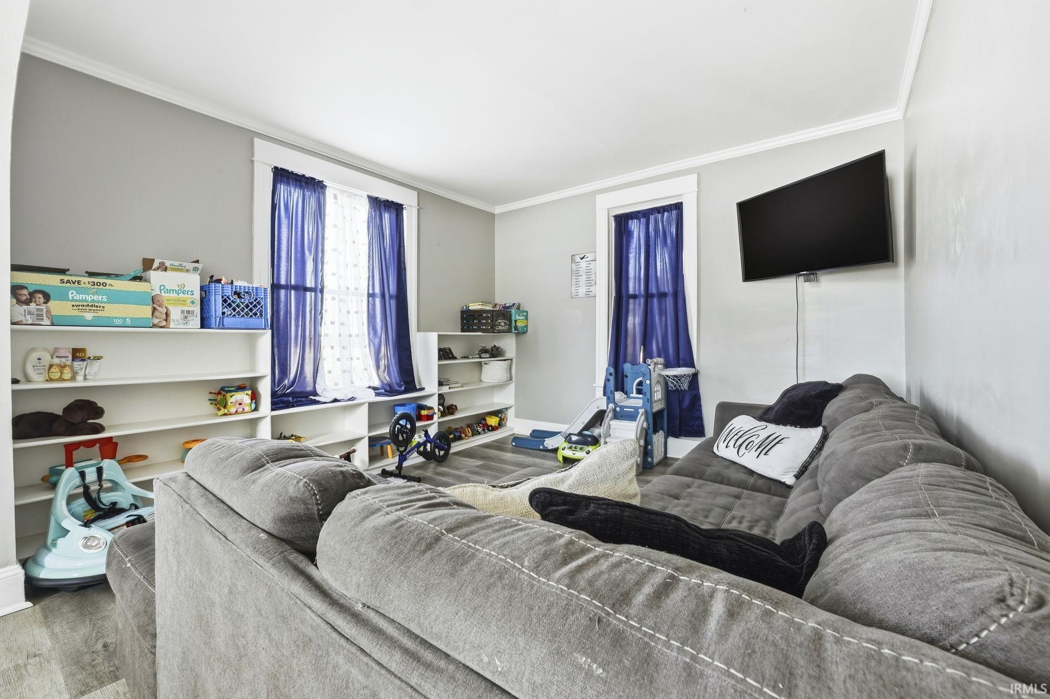 Living room featuring ornamental molding and wood finished floors