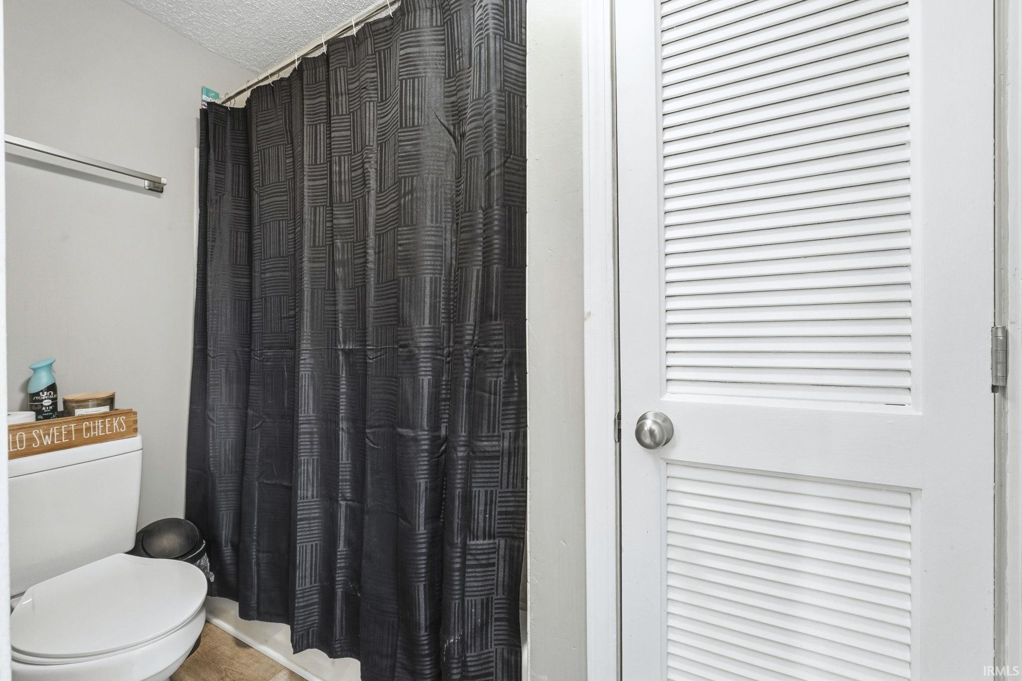 Full bathroom featuring a shower with shower curtain and a textured ceiling