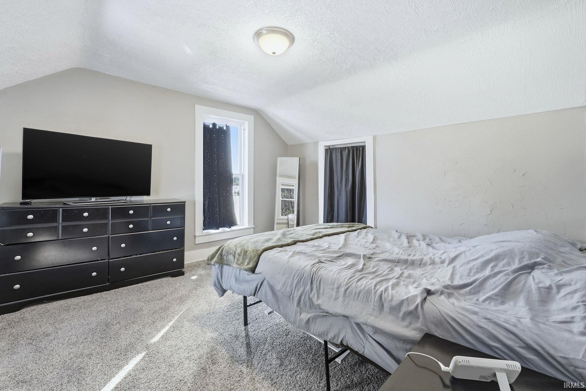 Carpeted bedroom featuring a textured ceiling