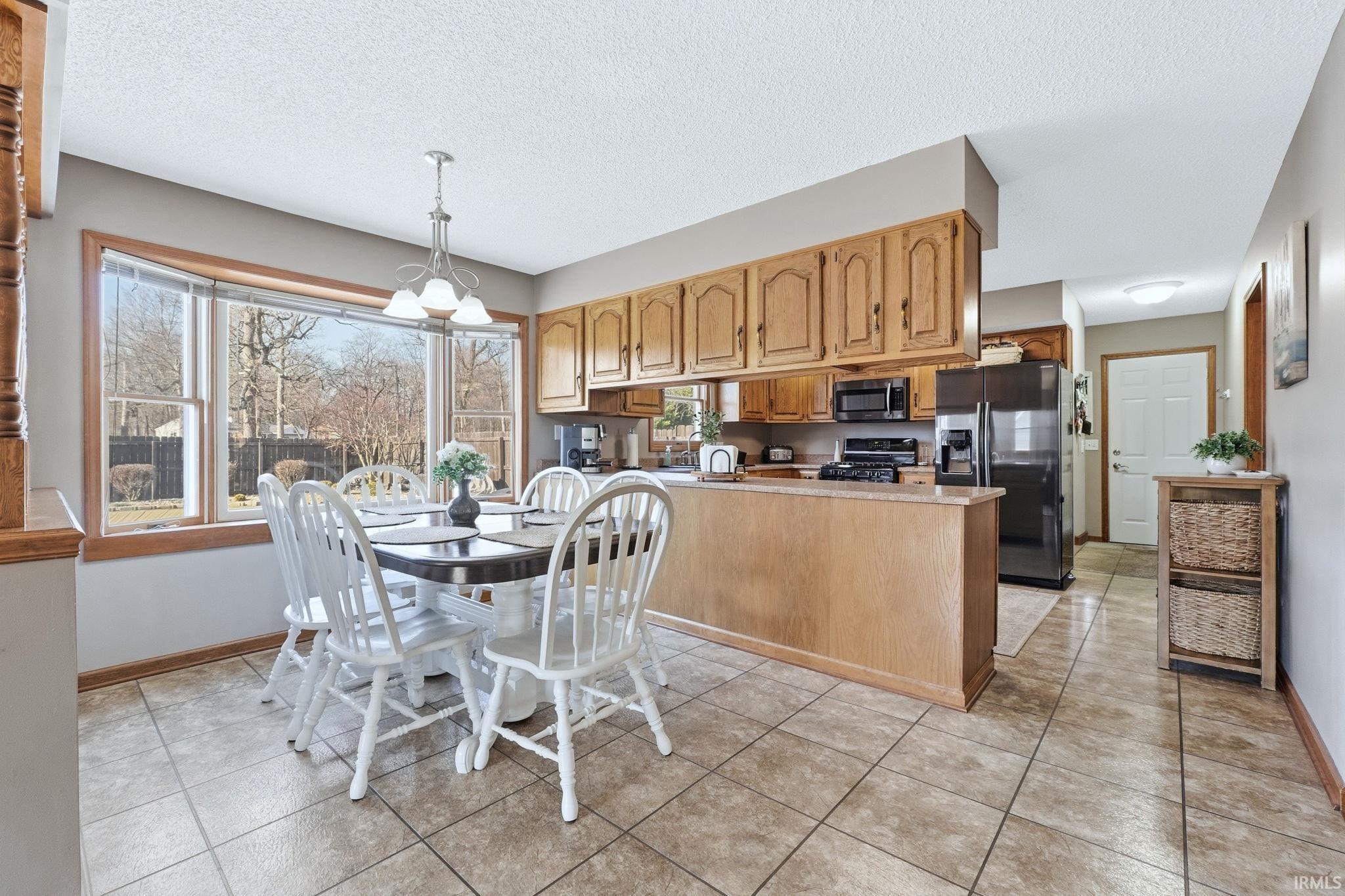Dining area featuring a textured ceiling and light tile patterned flooring