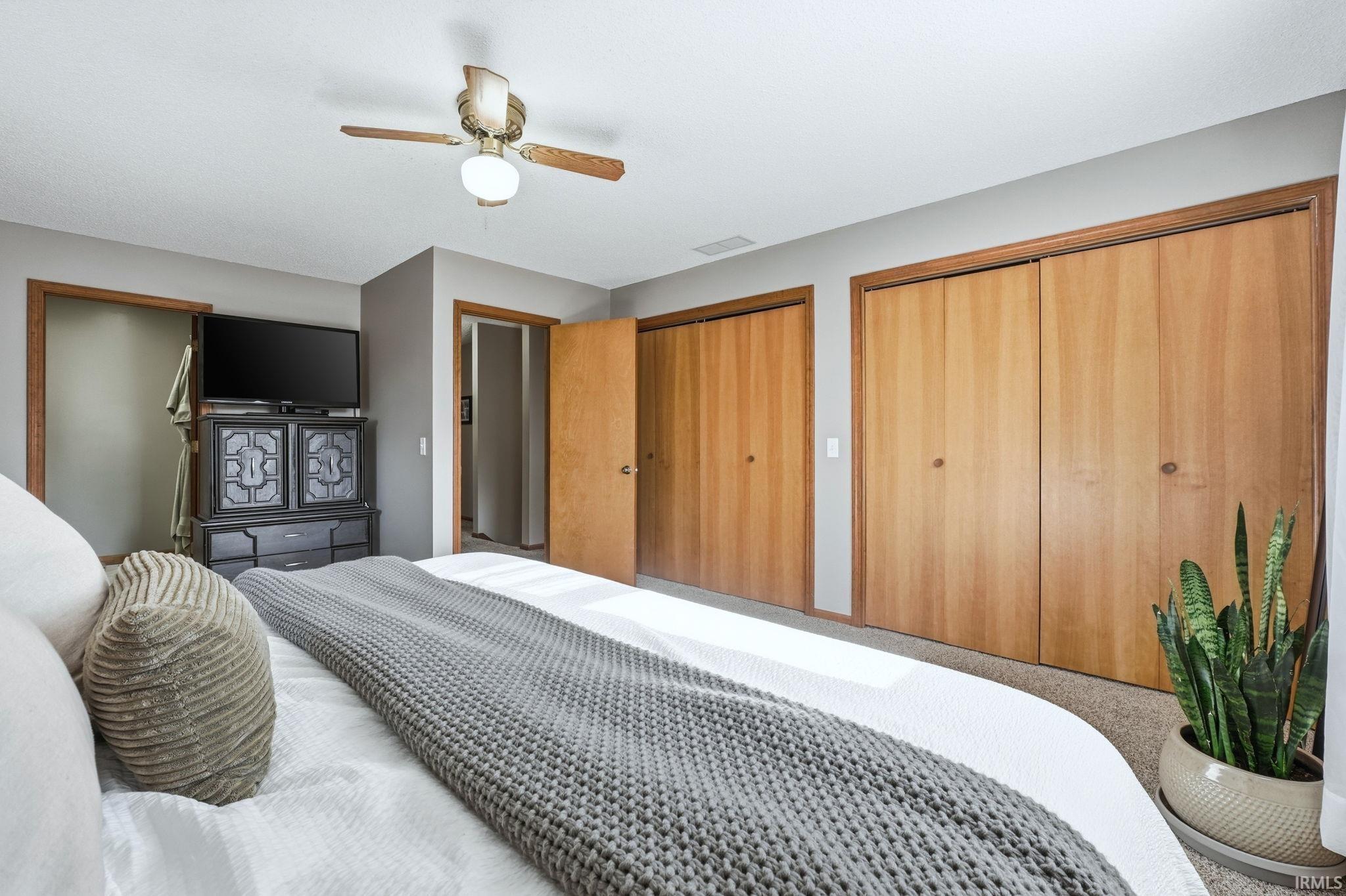 Bedroom with multiple closets and a ceiling fan