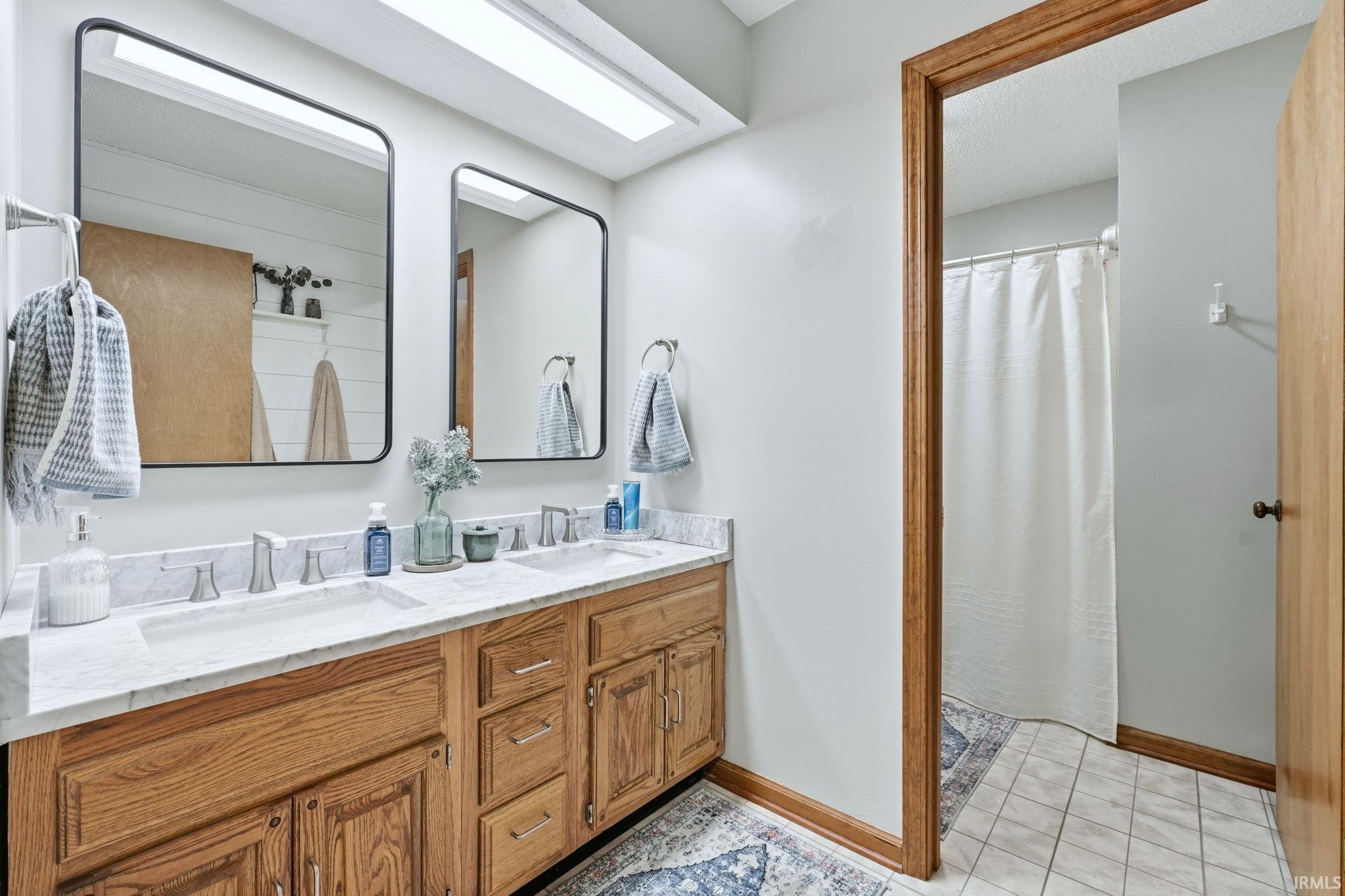 Bathroom featuring double vanity and curtained shower