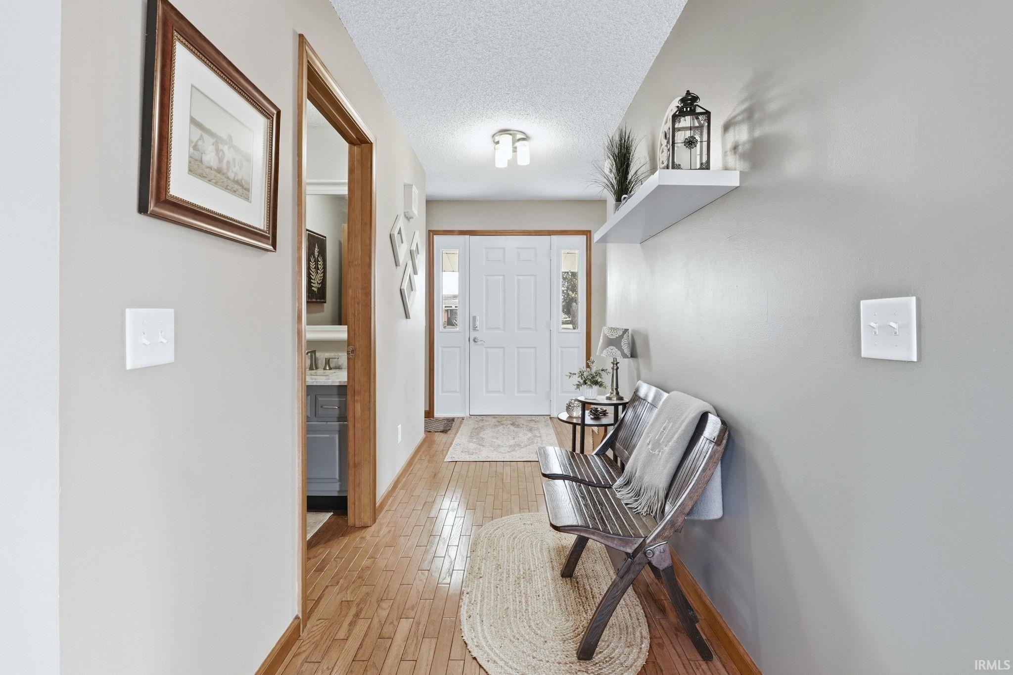 Entryway with a textured ceiling and light wood-style floors