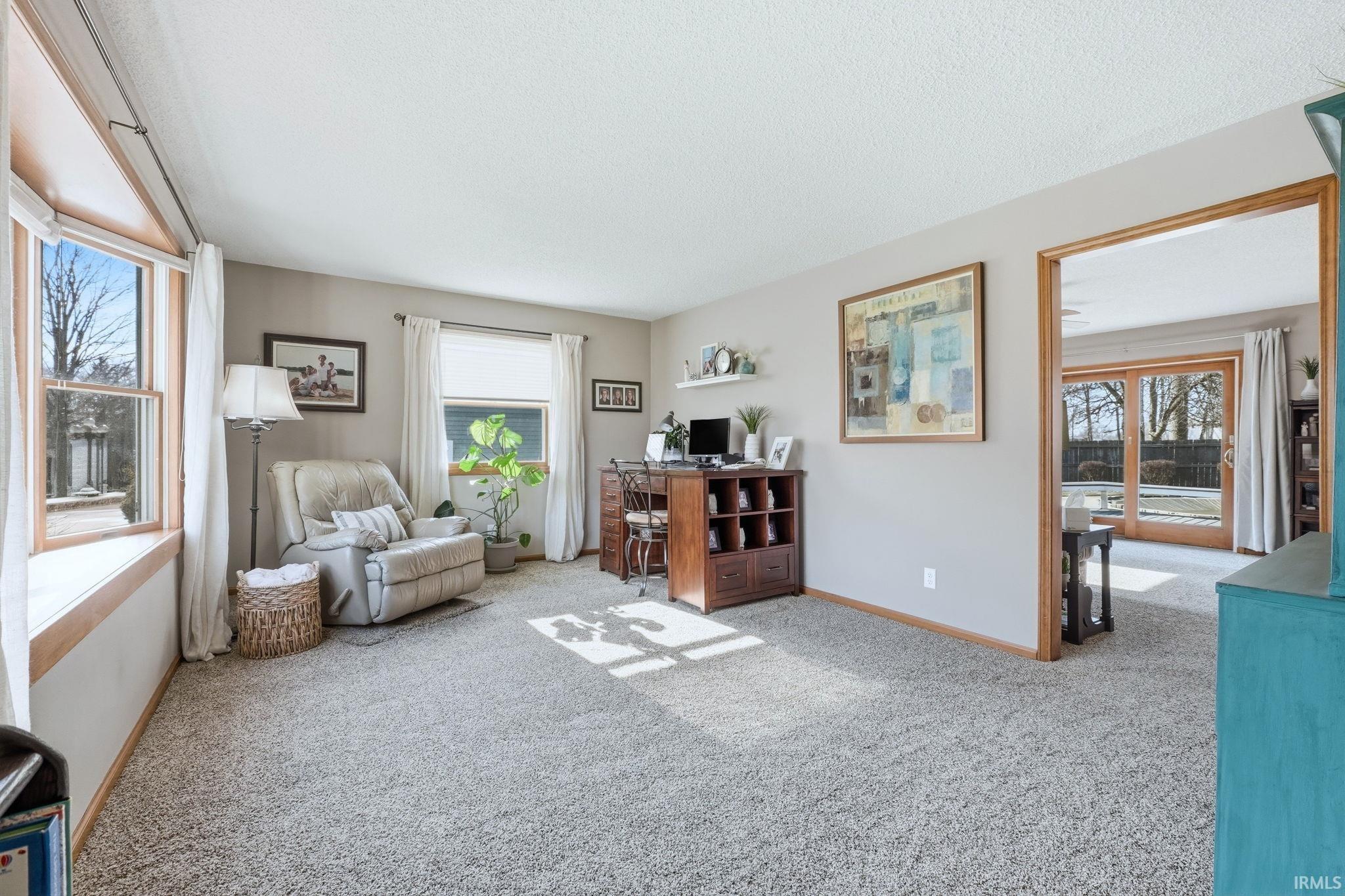 Living area with light carpet and a desk