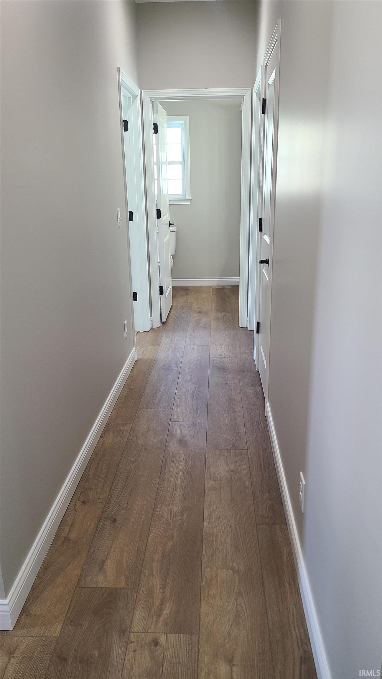 Corridor with dark wood finished floors and baseboards