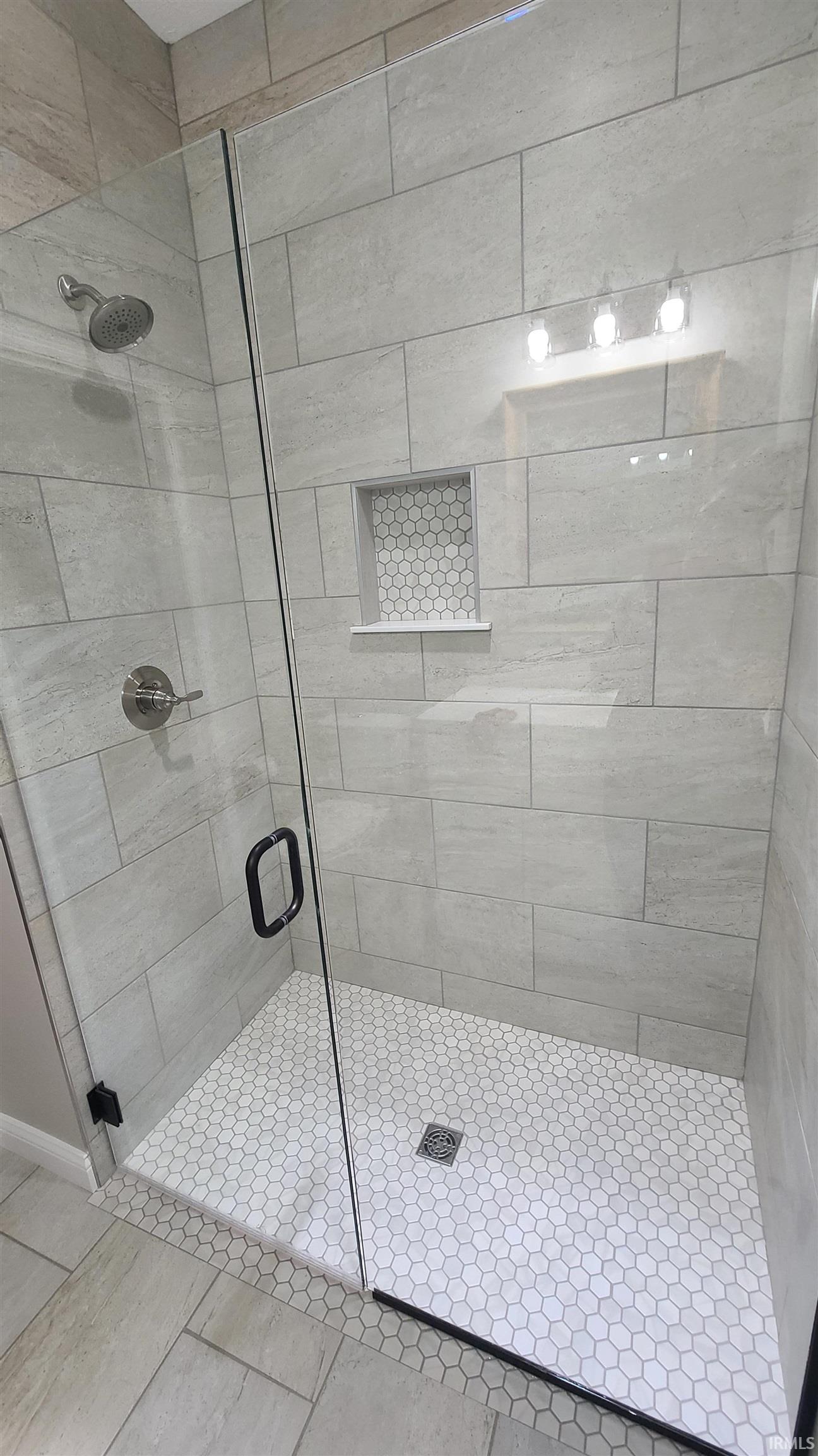 Bathroom with a stall shower and tile patterned flooring