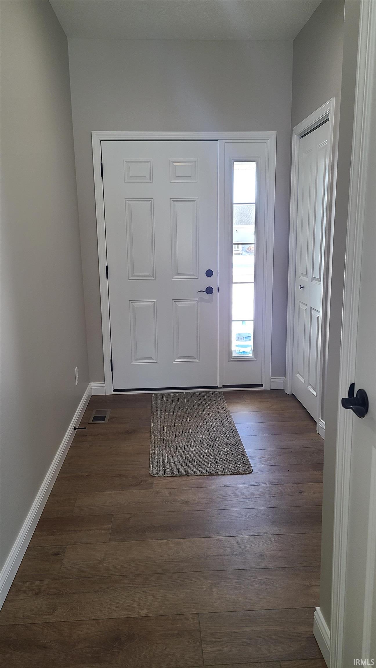 Foyer with baseboards and dark wood finished floors