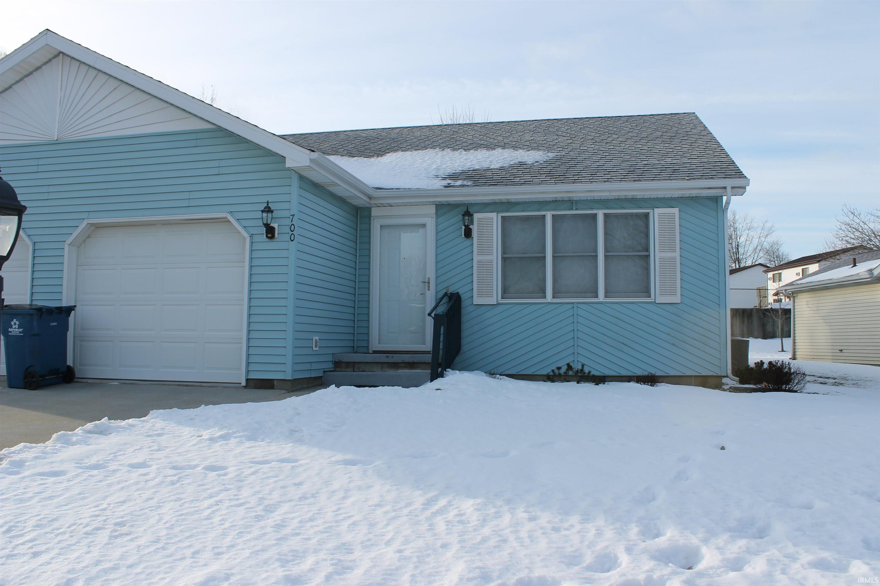 View of front of home featuring a shingled roof and an attached garage