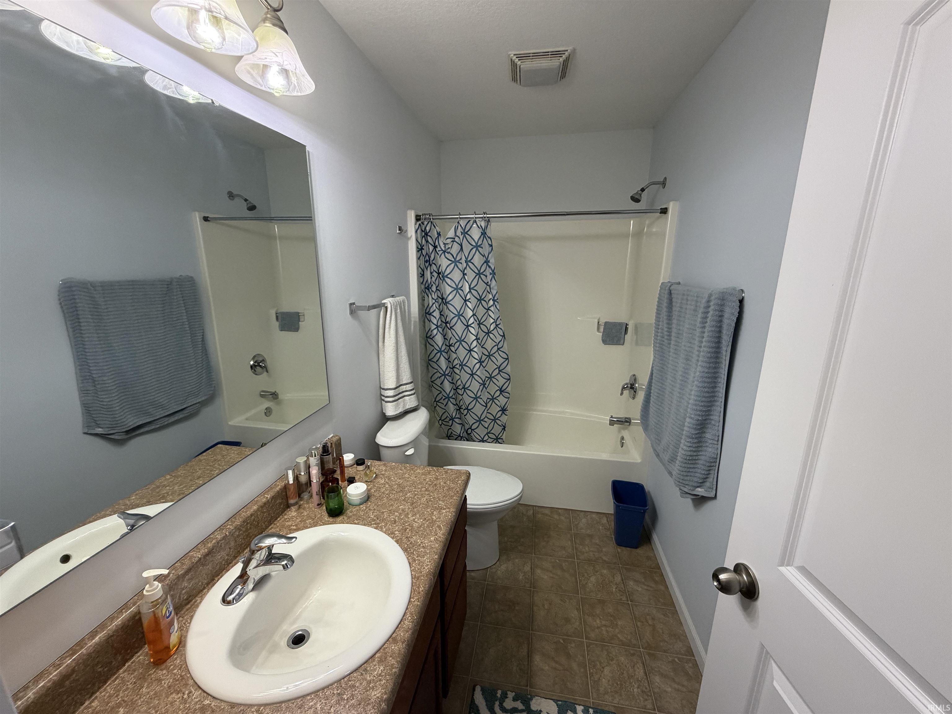Full bath featuring shower / bathtub combination with curtain and vanity
