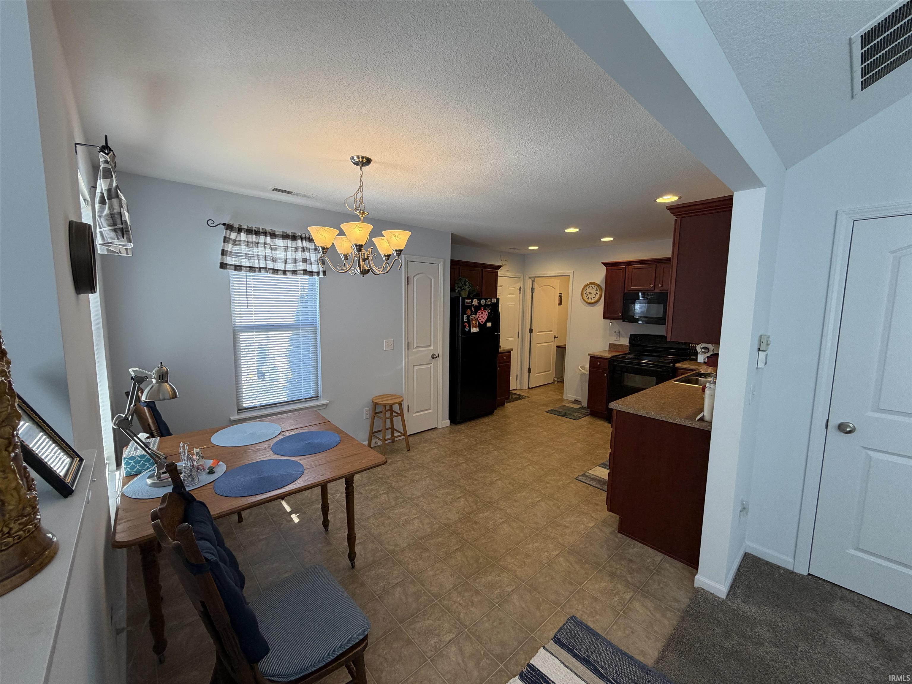 Dining space with a chandelier and a textured ceiling