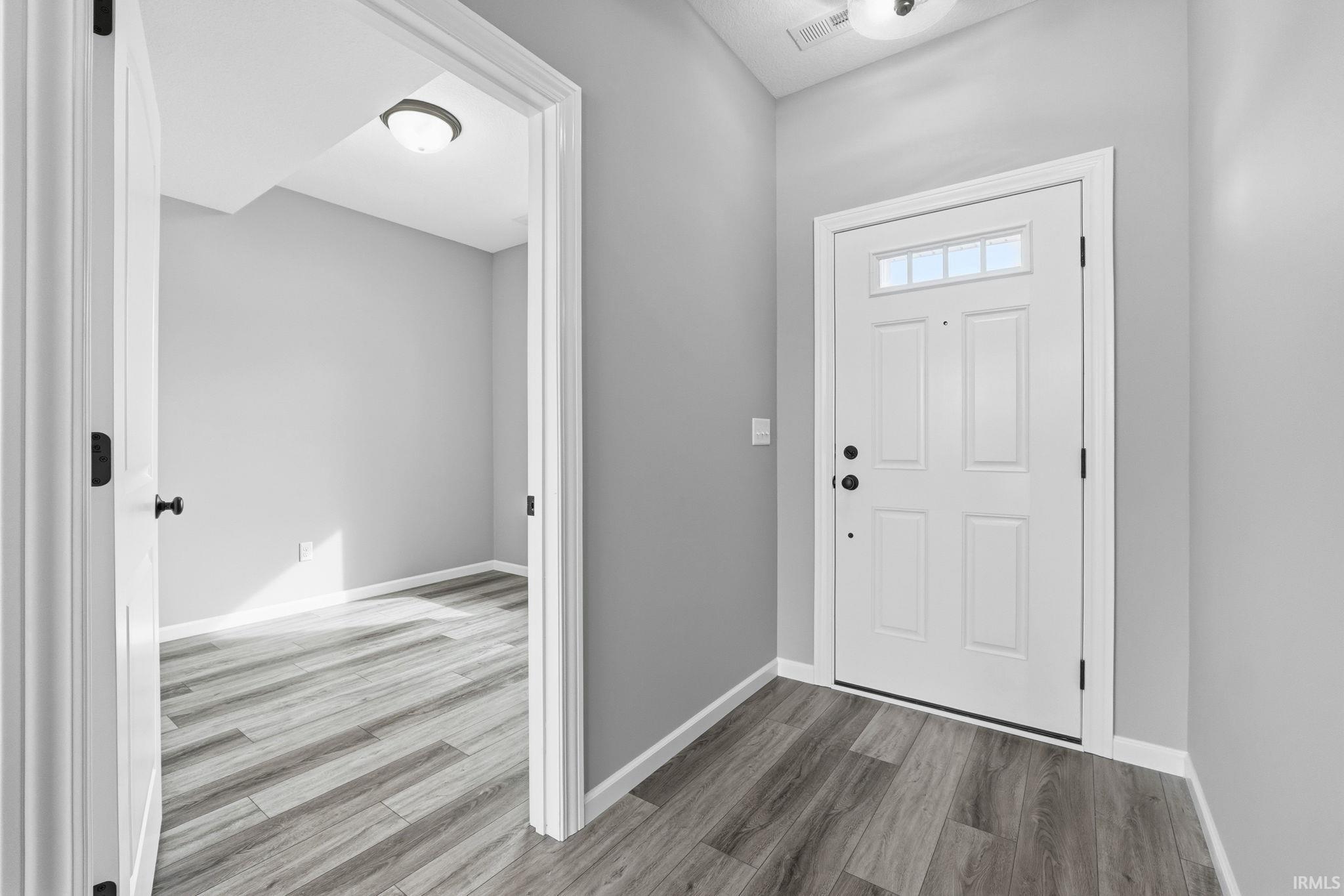 Entrance foyer with wood finished floors and baseboards