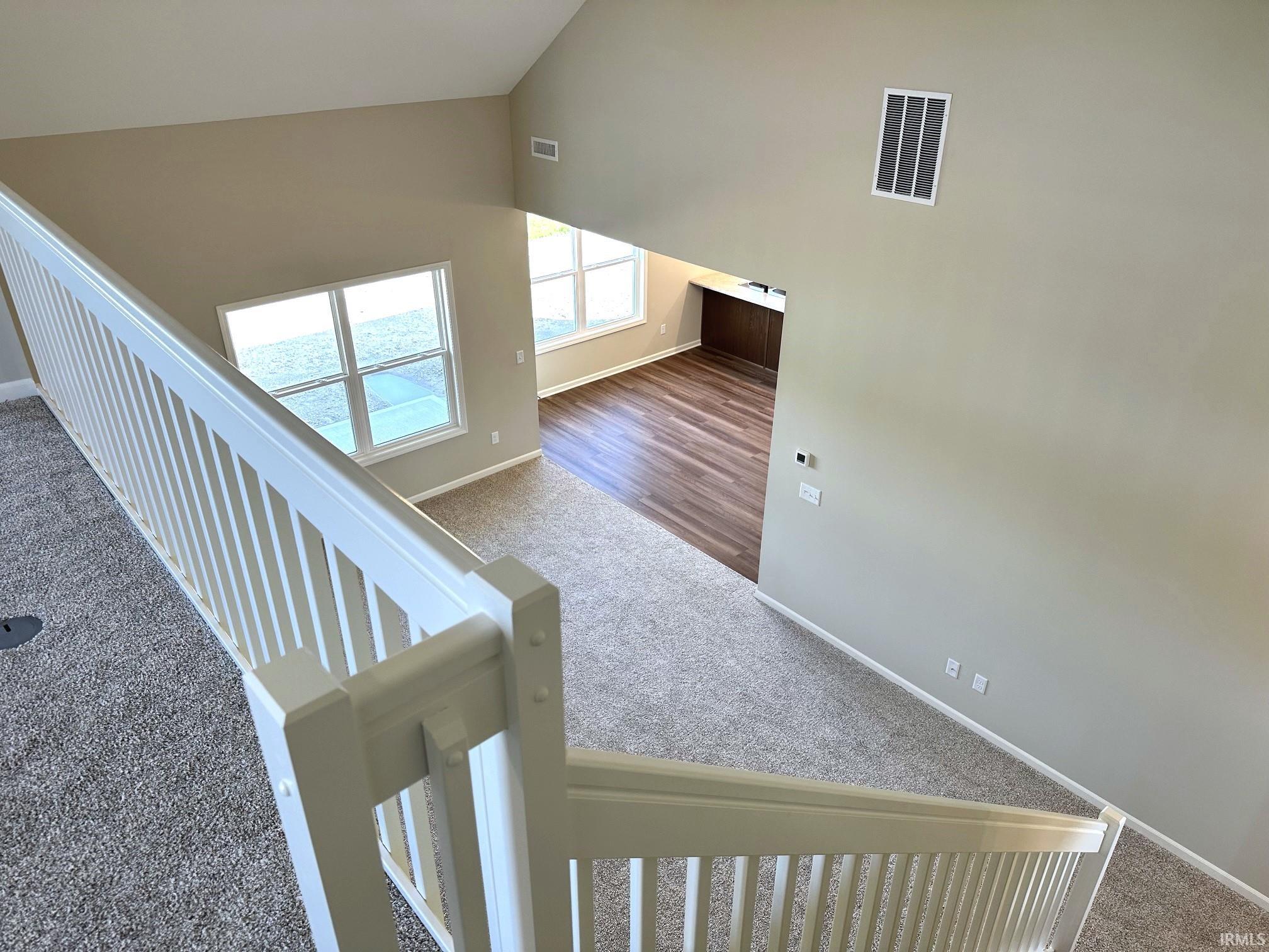 Stairway with carpet and a high ceiling