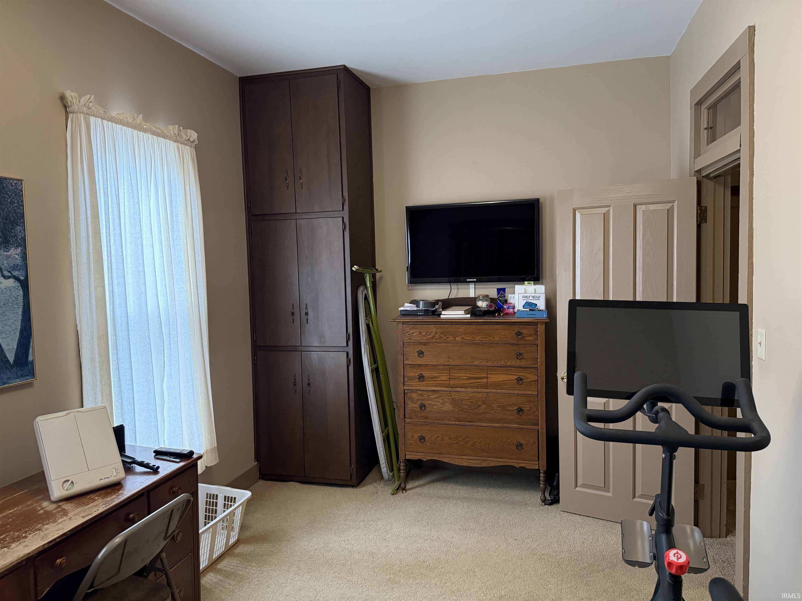 Bedroom featuring a desk and light carpet