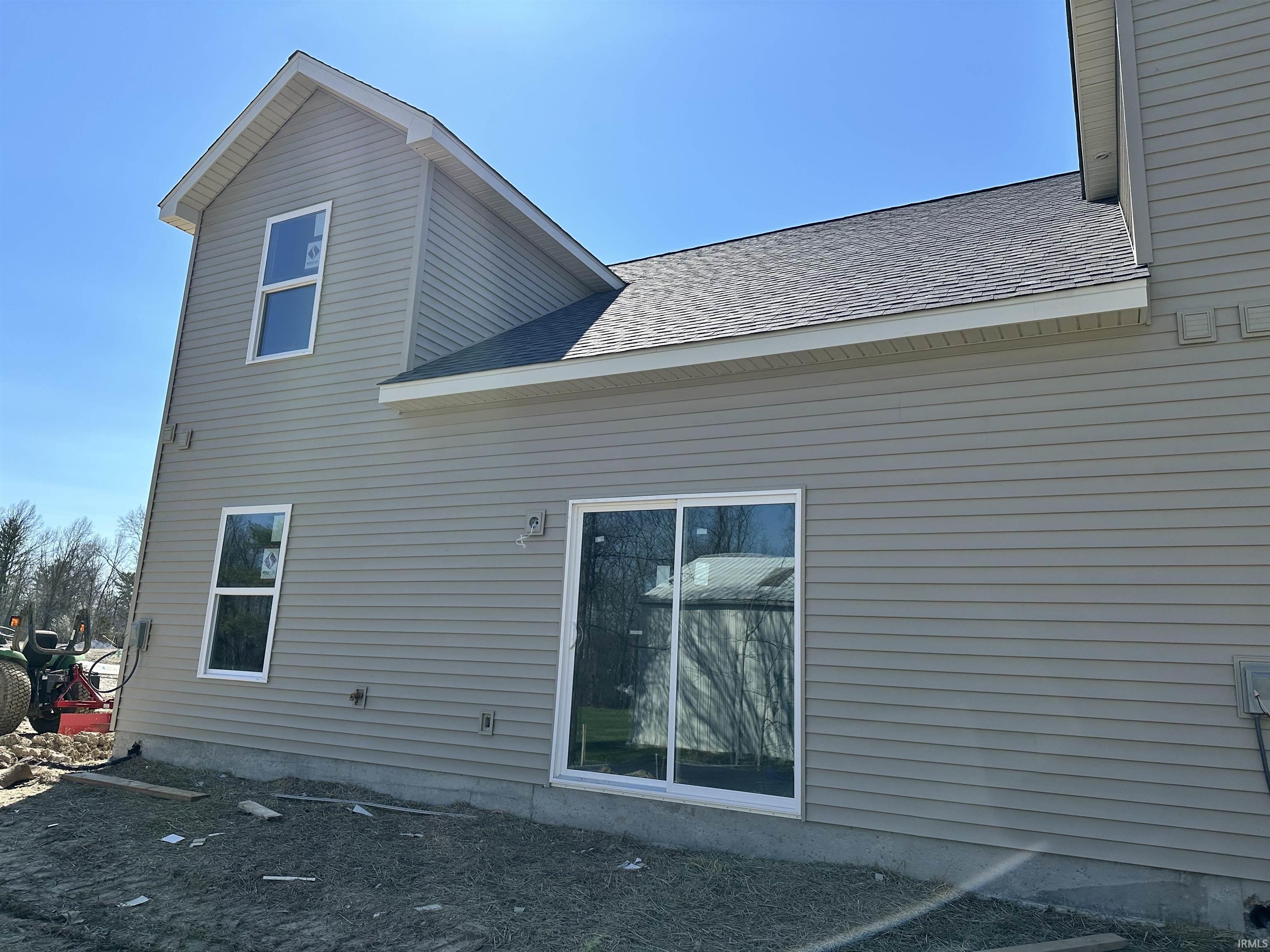 Rear view of house featuring a shingled roof