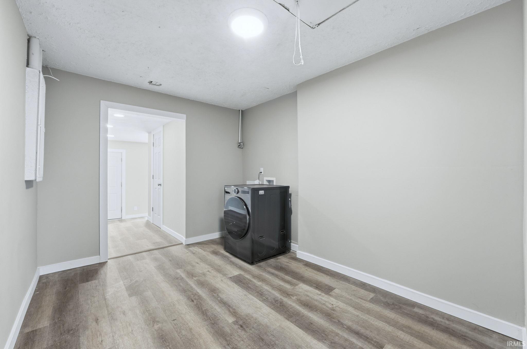 Washroom featuring washer / dryer and wood finished floors