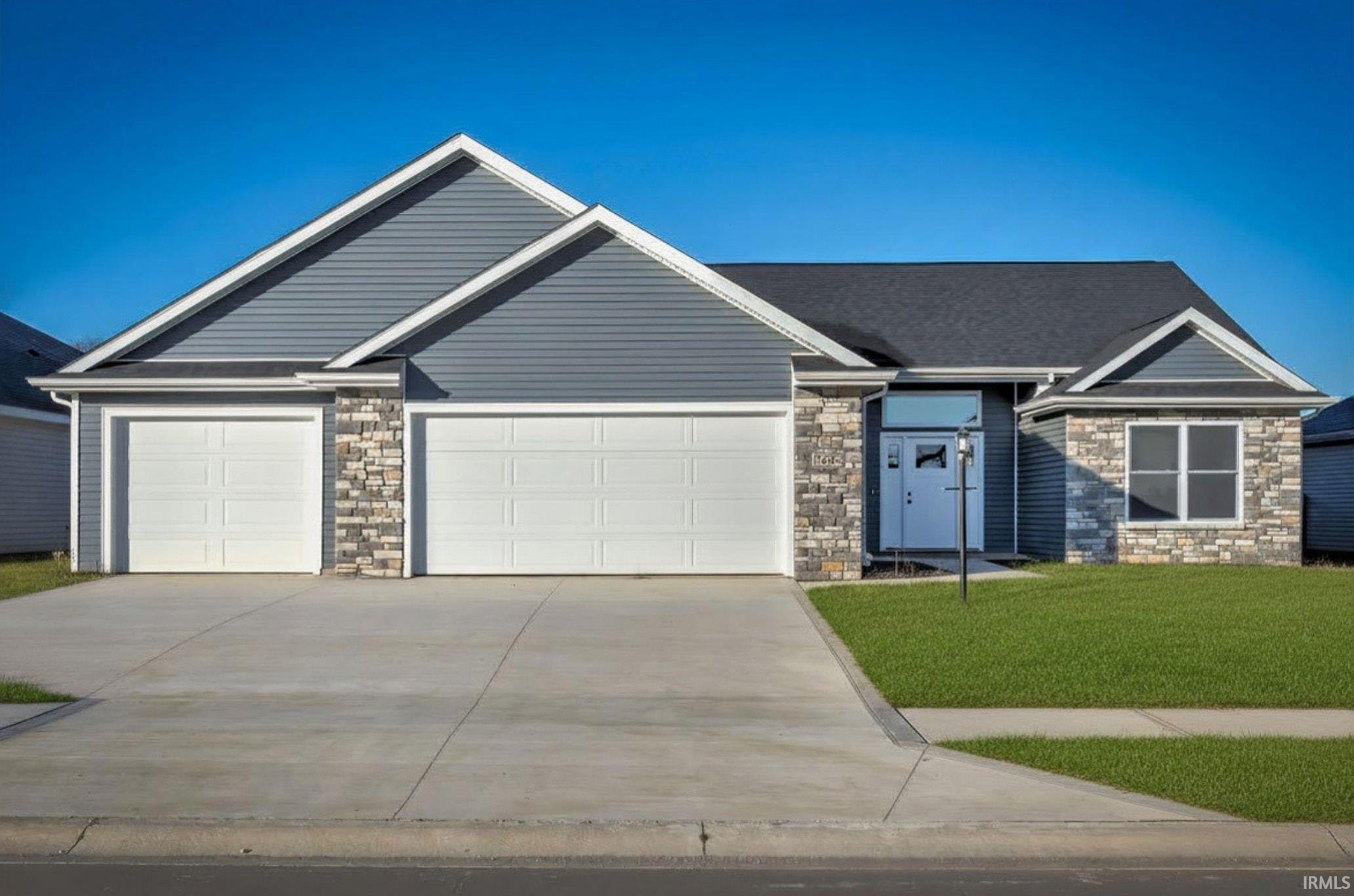 Contemporary ranch-style residence featuring a two-car garage, stone and siding exterior, a light blue entry door, and a manicured lawn
