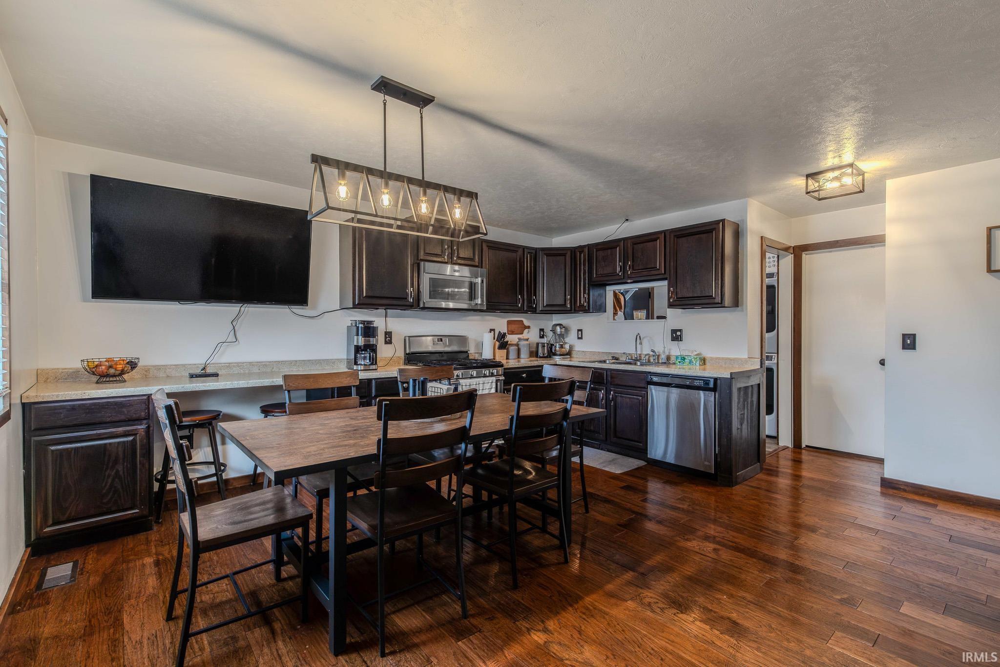 Dining room with dark wood-type flooring and a textured ceiling