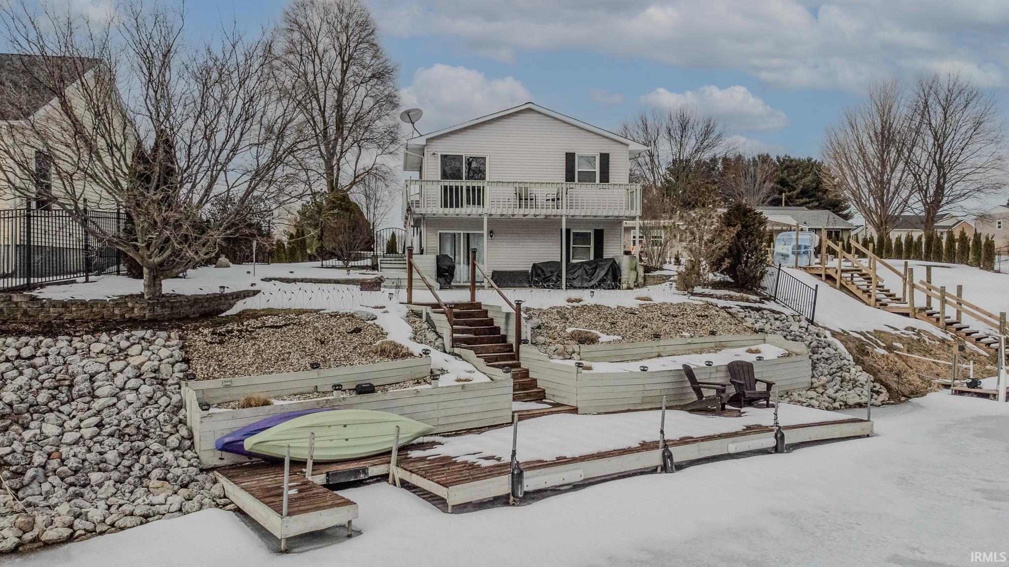 Snow covered house with stairs and a deck