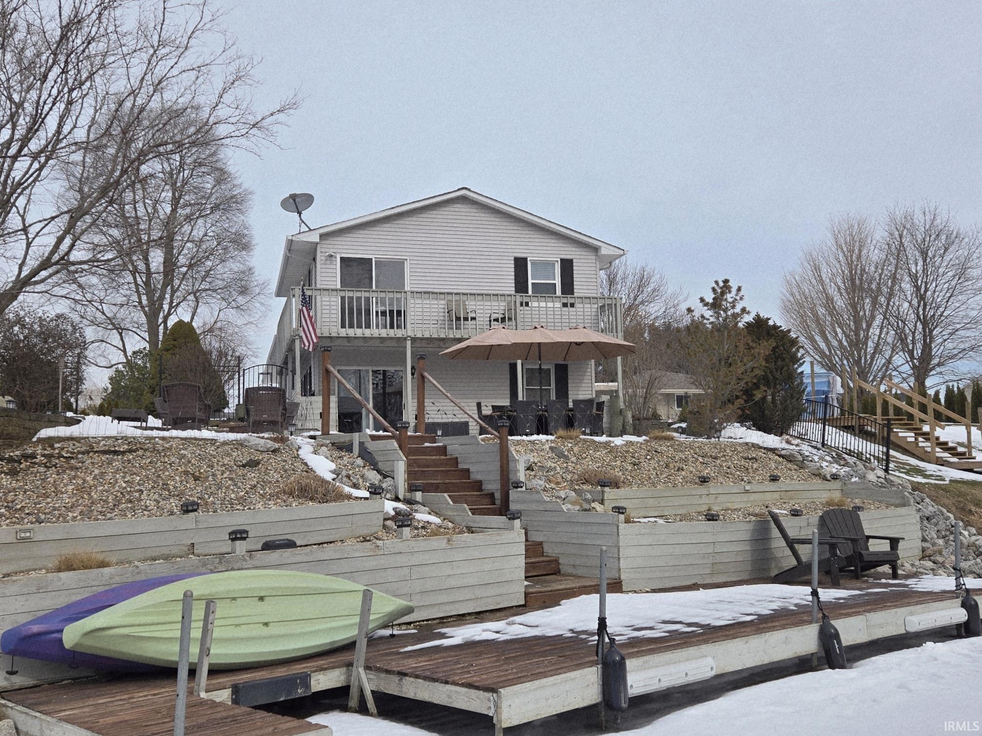 Snow covered rear of property featuring stairs and a deck