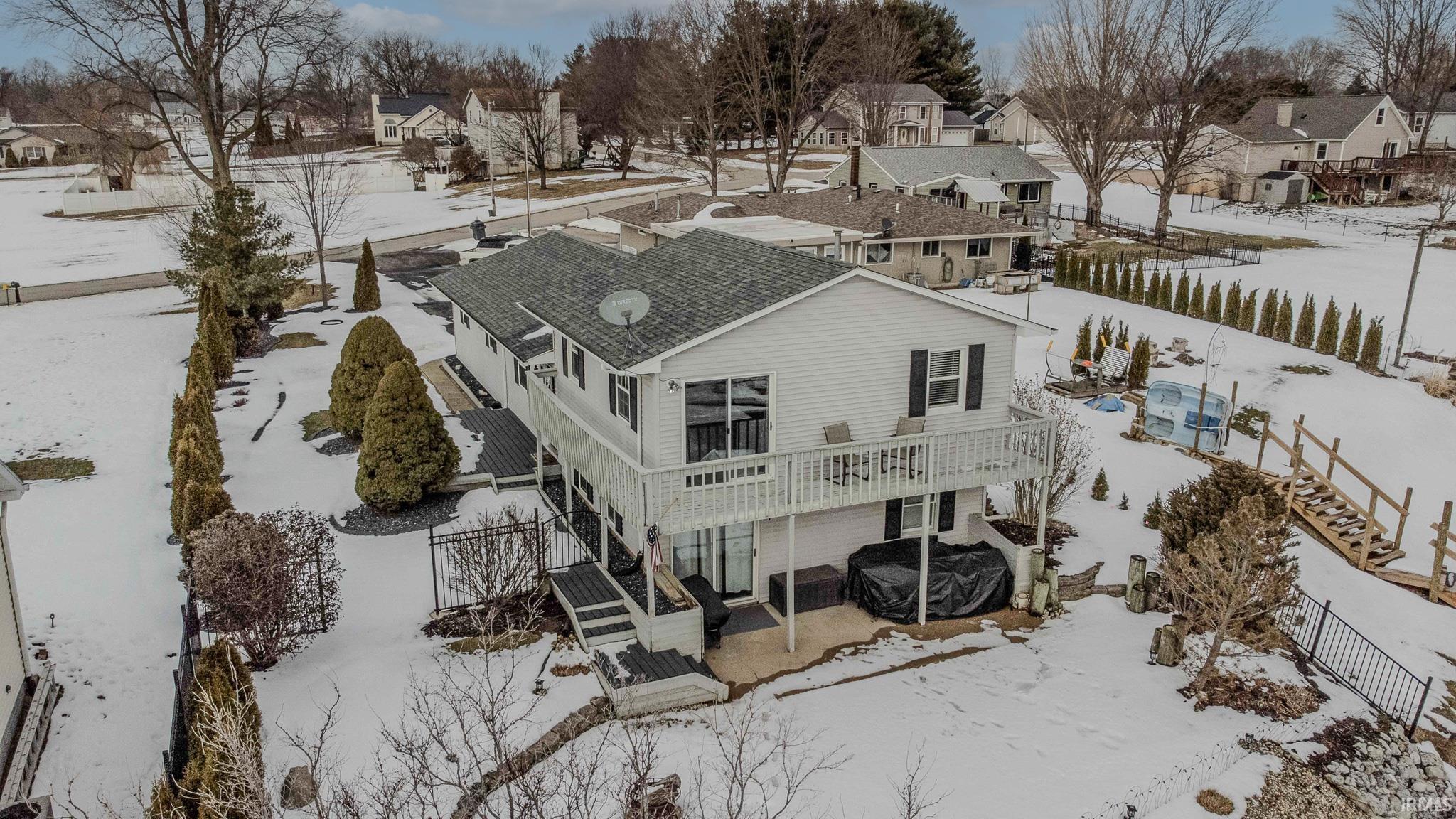 Snow covered property featuring a residential view, a patio area, and a fenced backyard