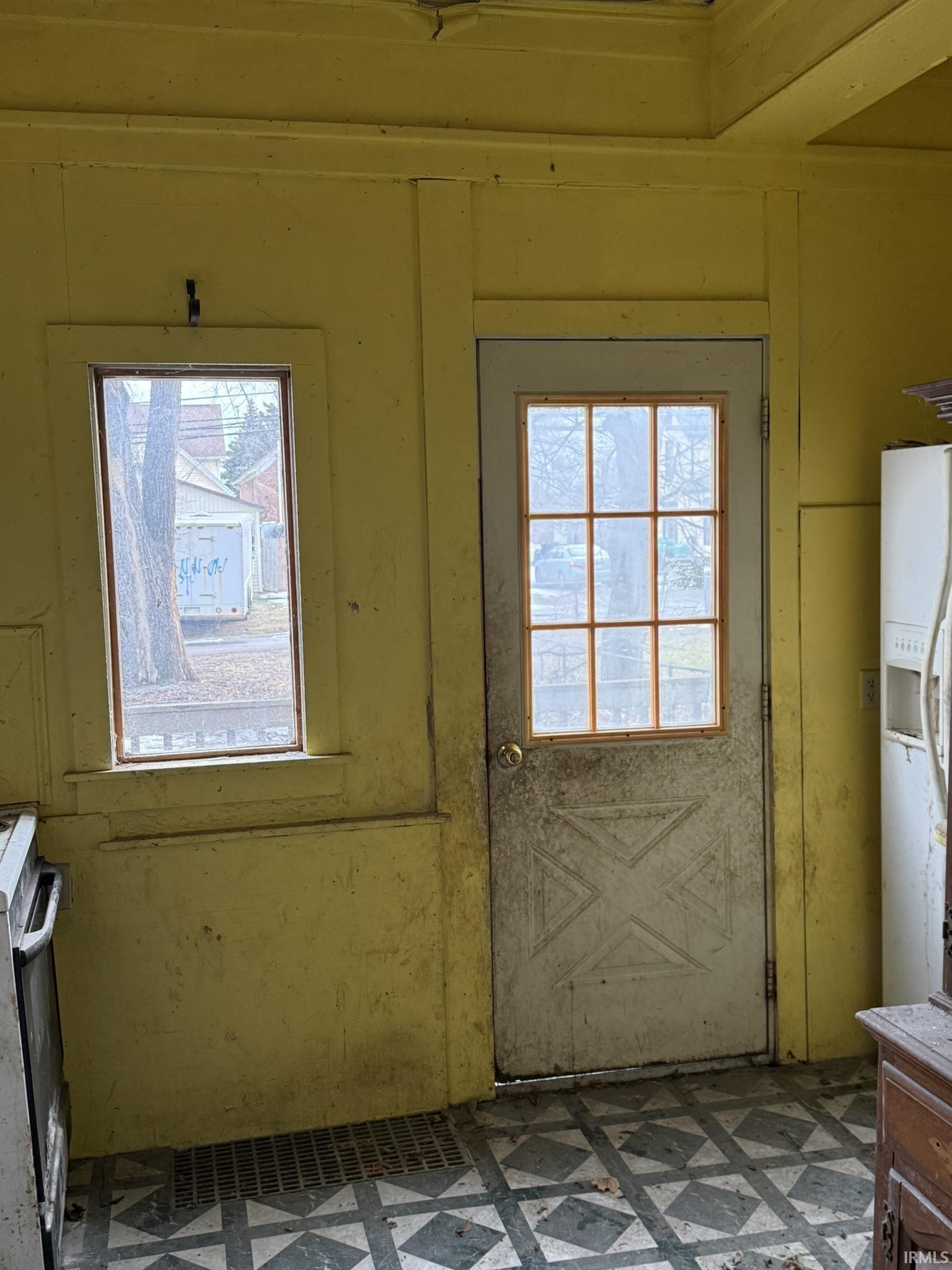 Doorway with healthy amount of natural light and tile patterned floors