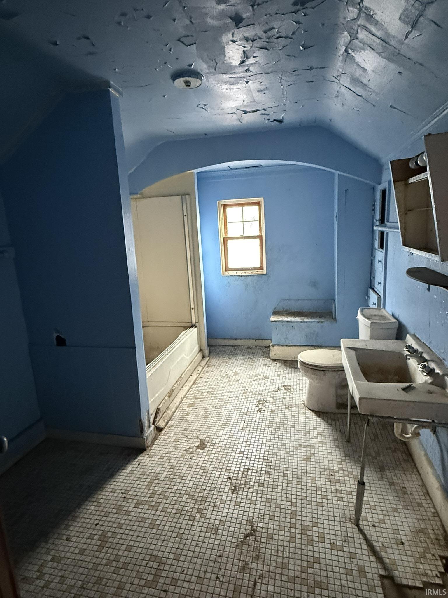 Bonus room with a sink and baseboards